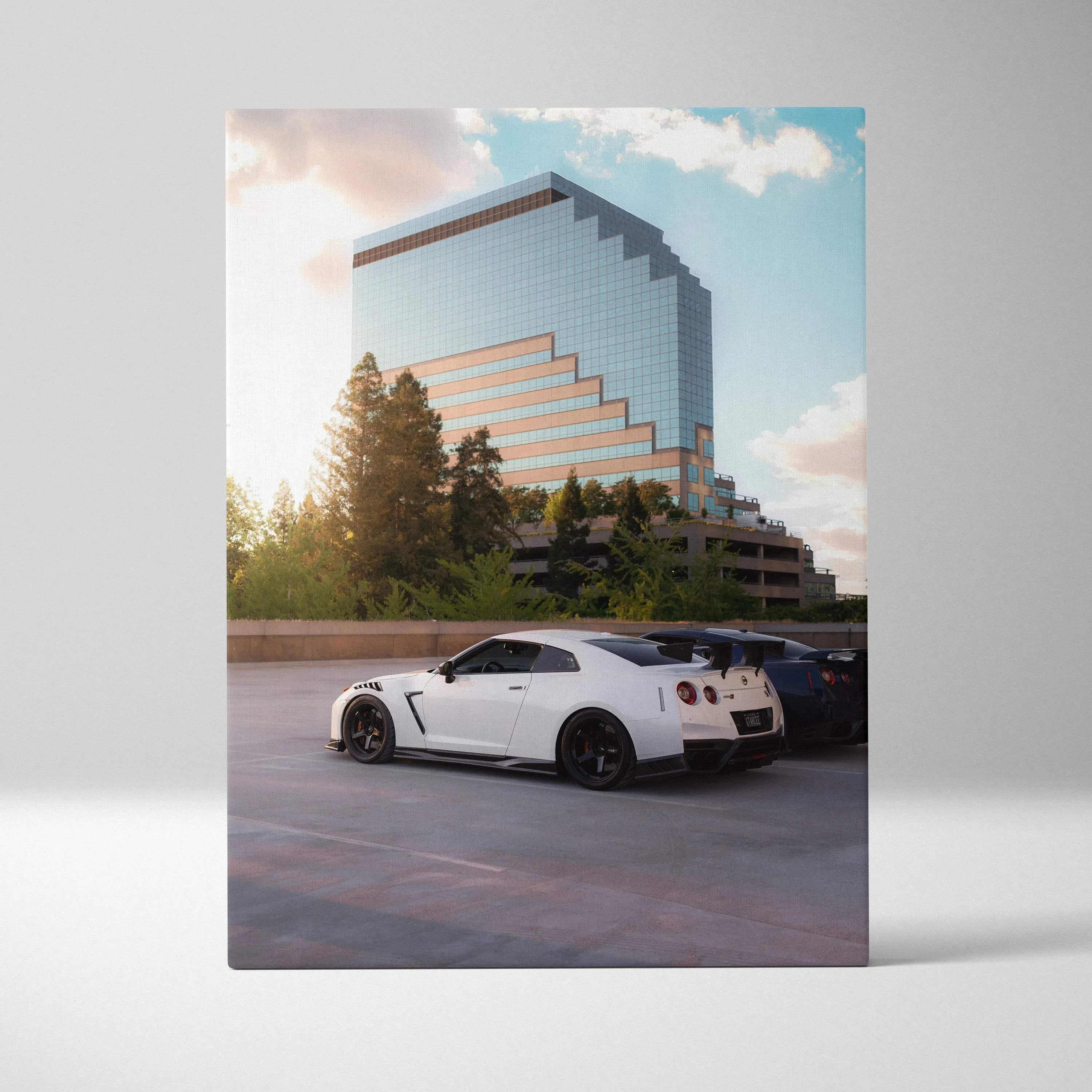 White Nissan GTR R35 parked under a modern glass building canvas wall art in vertical orientation.