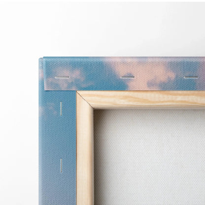 Close-up of wooden frame corner and canvas fabric with soft blue and pink sky, canvas wall art detail.