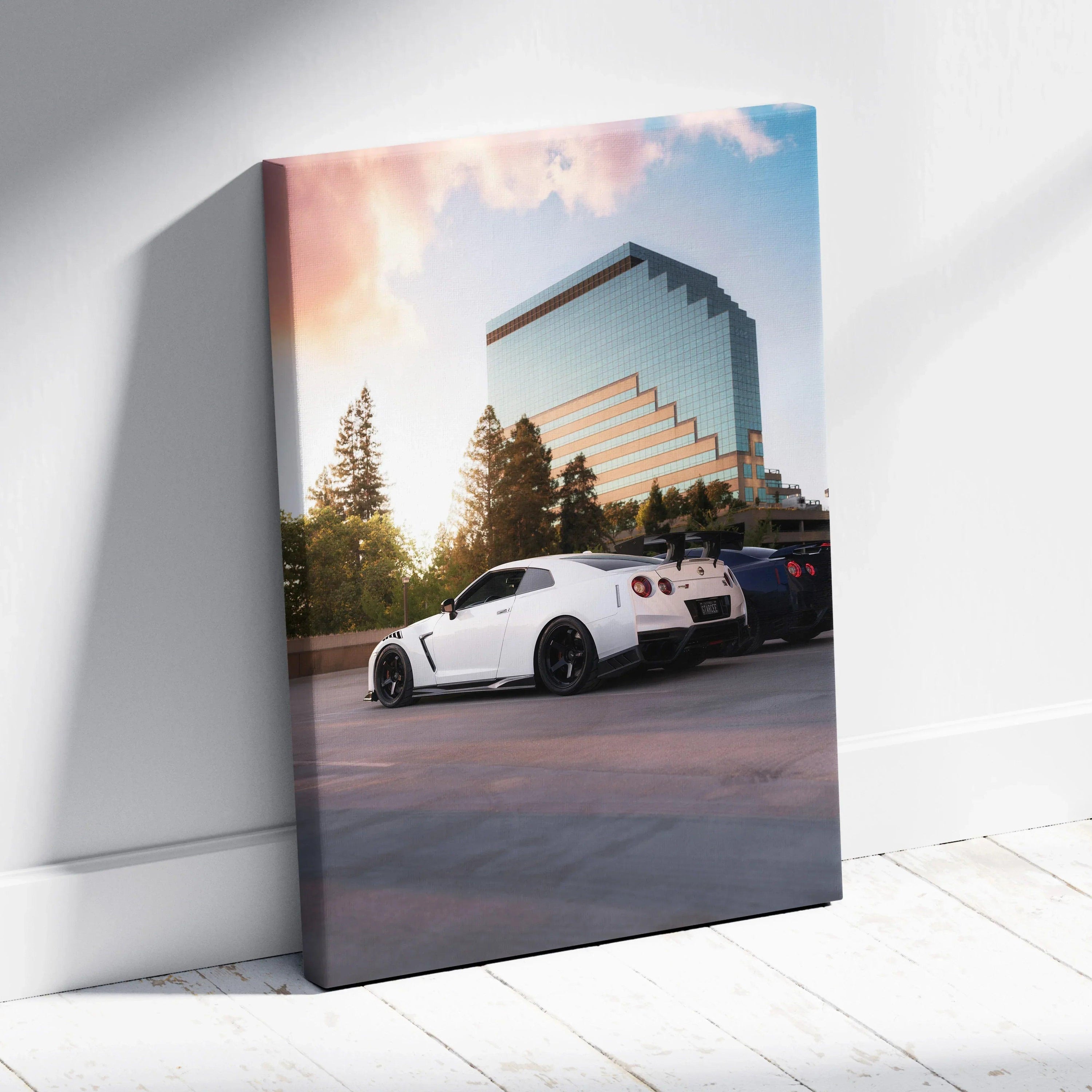 White Nissan GTR R35 parked by modern glass building under soft sunset sky vertical canvas wall art.