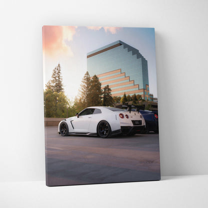 White Nissan GTR R35 parked near modern glass building at sunset canvas wall art.