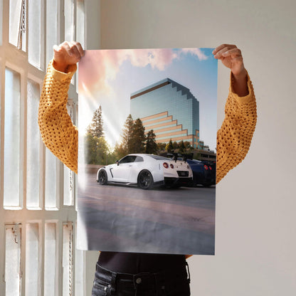 Nissan GTR R35 parked by modern building at sunset poster wall art with vibrant sky.