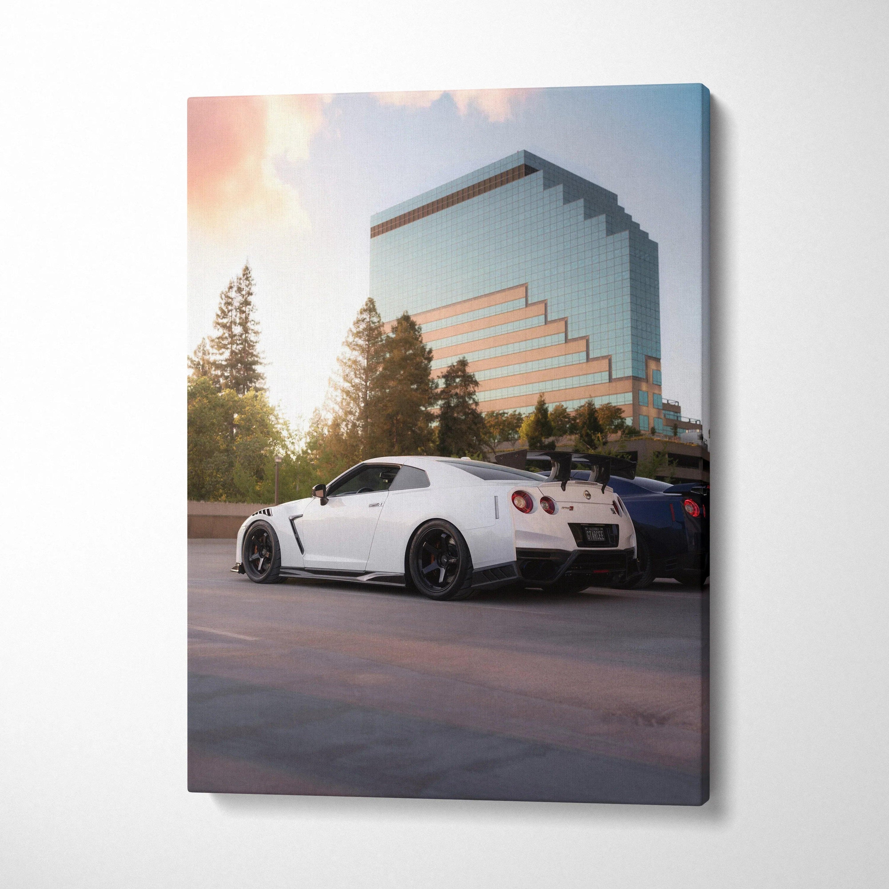 White Nissan GTR R35 parked under sunset by modern glass building canvas wall art.