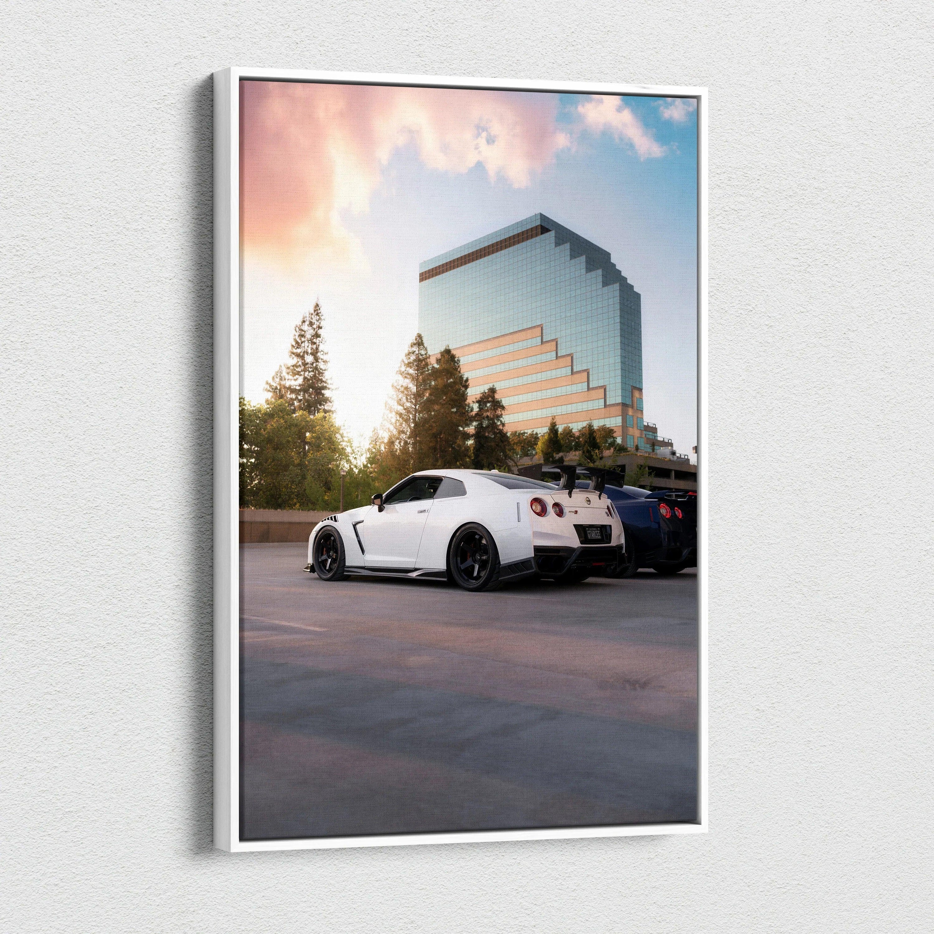 Vertical canvas wall art featuring a white Nissan R35 GTR parked against a sunset sky and modern glass building background.