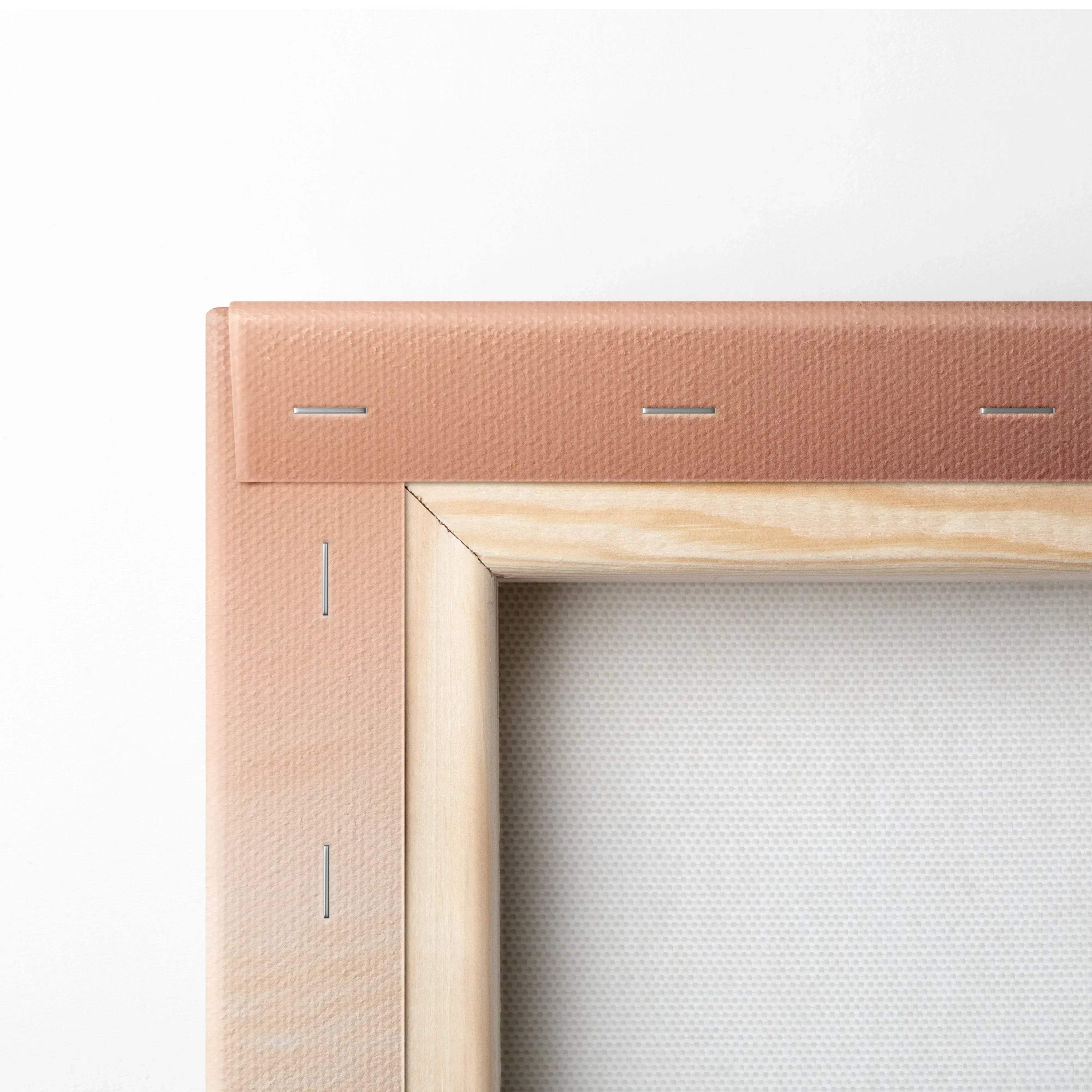 Close-up of pink-stretched canvas fabric wrapped on a wooden frame with metal staples securing the edges.