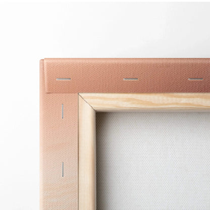Close-up of pink-stretched canvas fabric wrapped on a wooden frame with metal staples securing the edges.