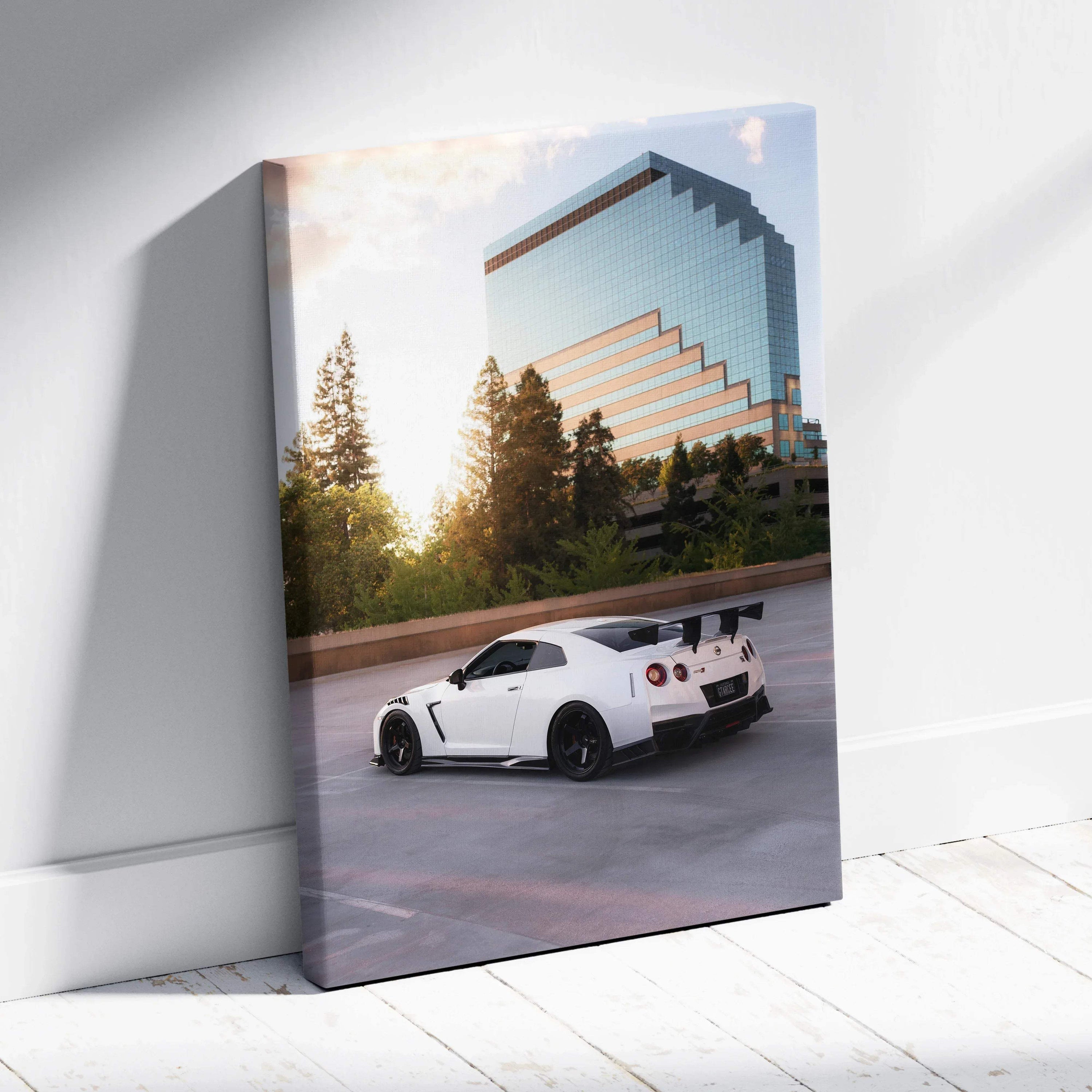 Vertical canvas art featuring a white Nissan GTR R35 parked by reflective modern building, wall art with sunset lighting.
