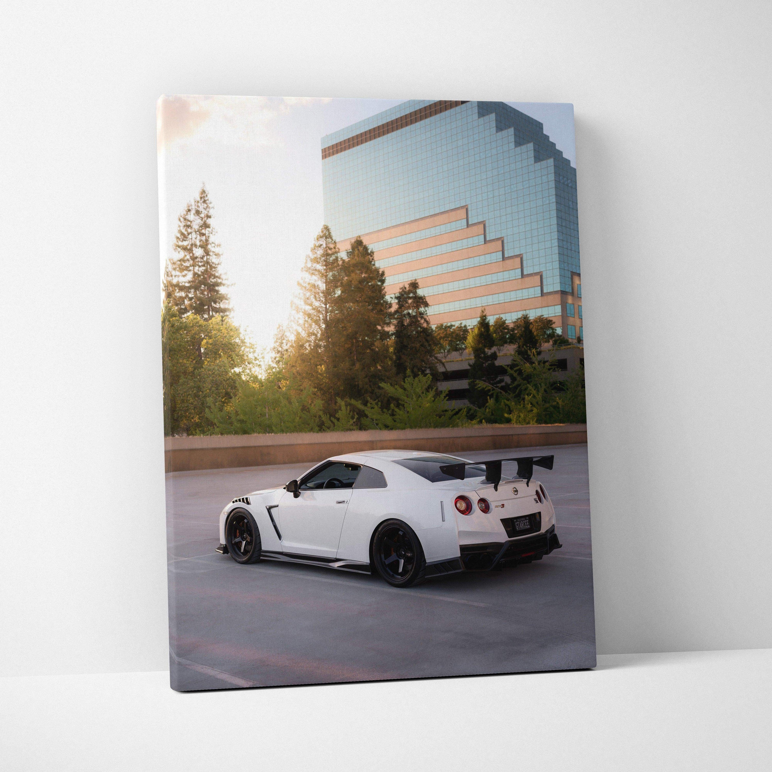 Nissan GTR R35 in white with black accents parked by modern glass building vertical canvas wall art.