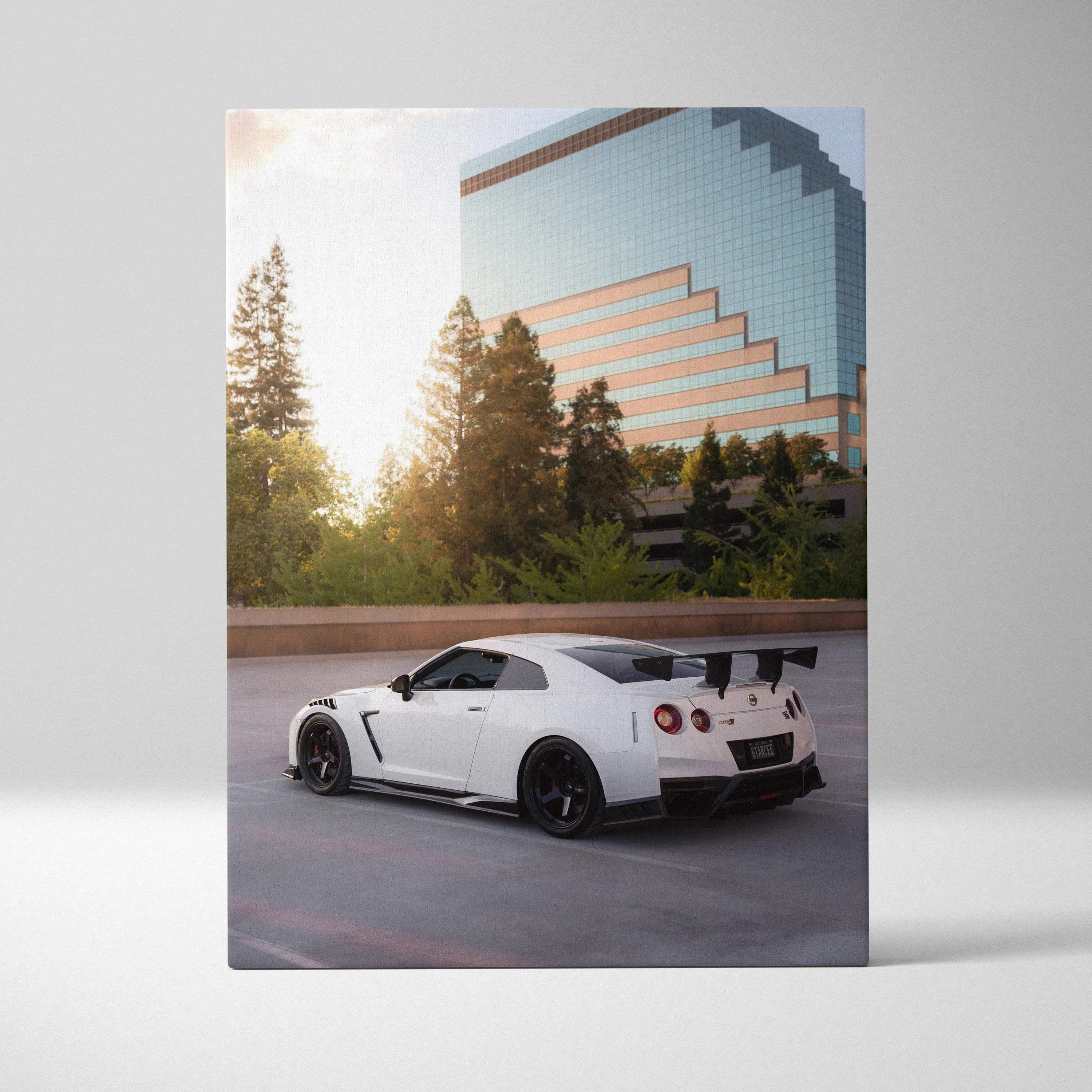 White Nissan GTR R35 sports car with black spoiler parked in front of glass building canvas wall art.