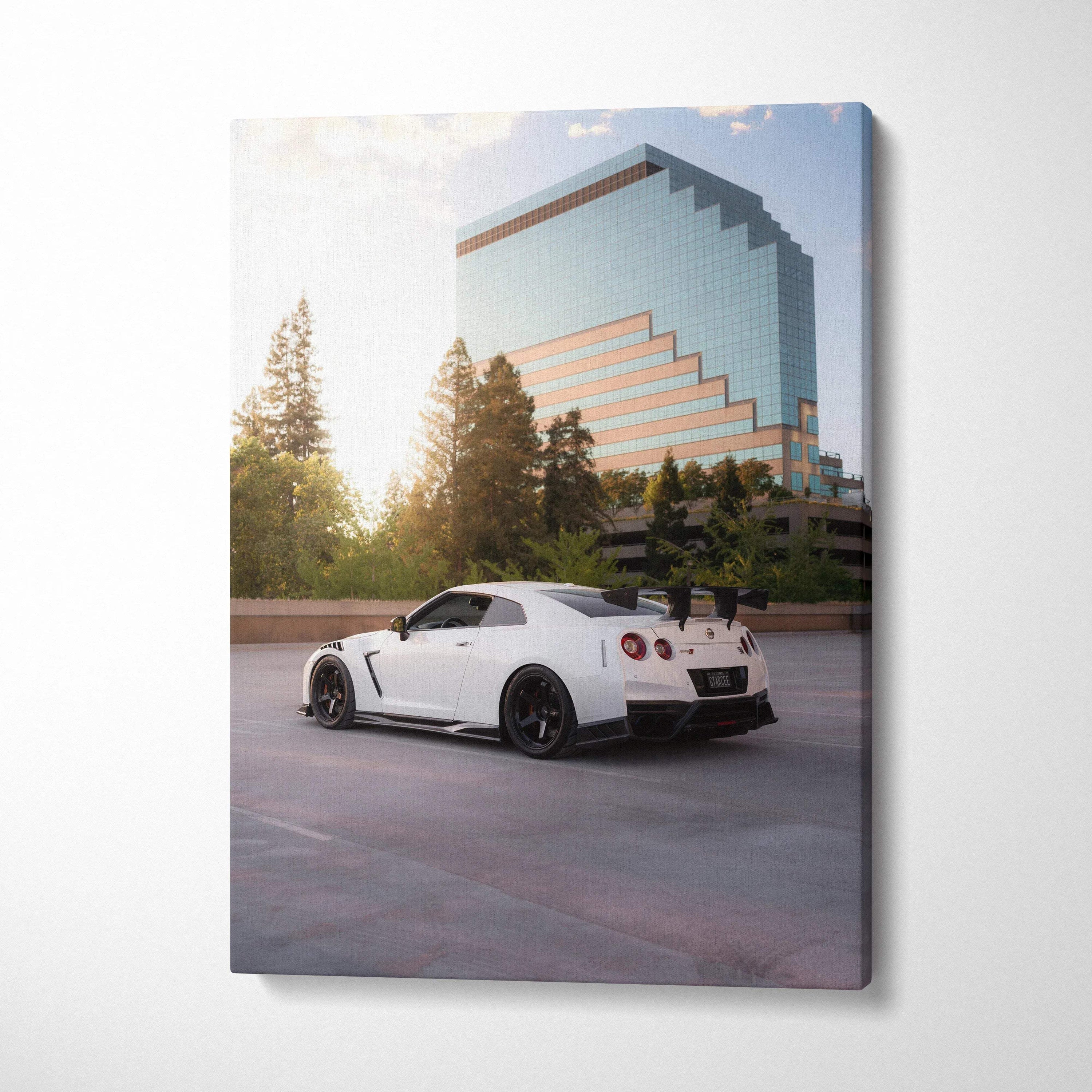 Vertical canvas wall art of a white Nissan R35 GTR parked with a modern glass building background.