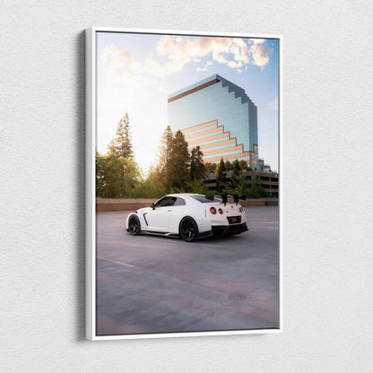 Vertical canvas wall art featuring a white Nissan GTR R35 parked by a modern glass building at sunset.