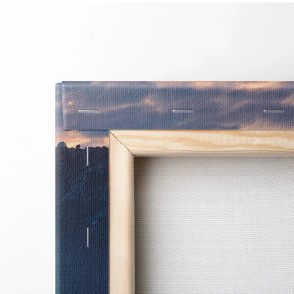 Close-up of wooden-framed canvas wall art with cityscape and cloudy sky print.