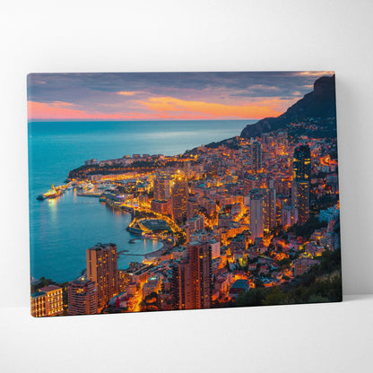 Canvas wall art print featuring a vibrant cityscape at sunset with illuminated buildings and a coastal view.