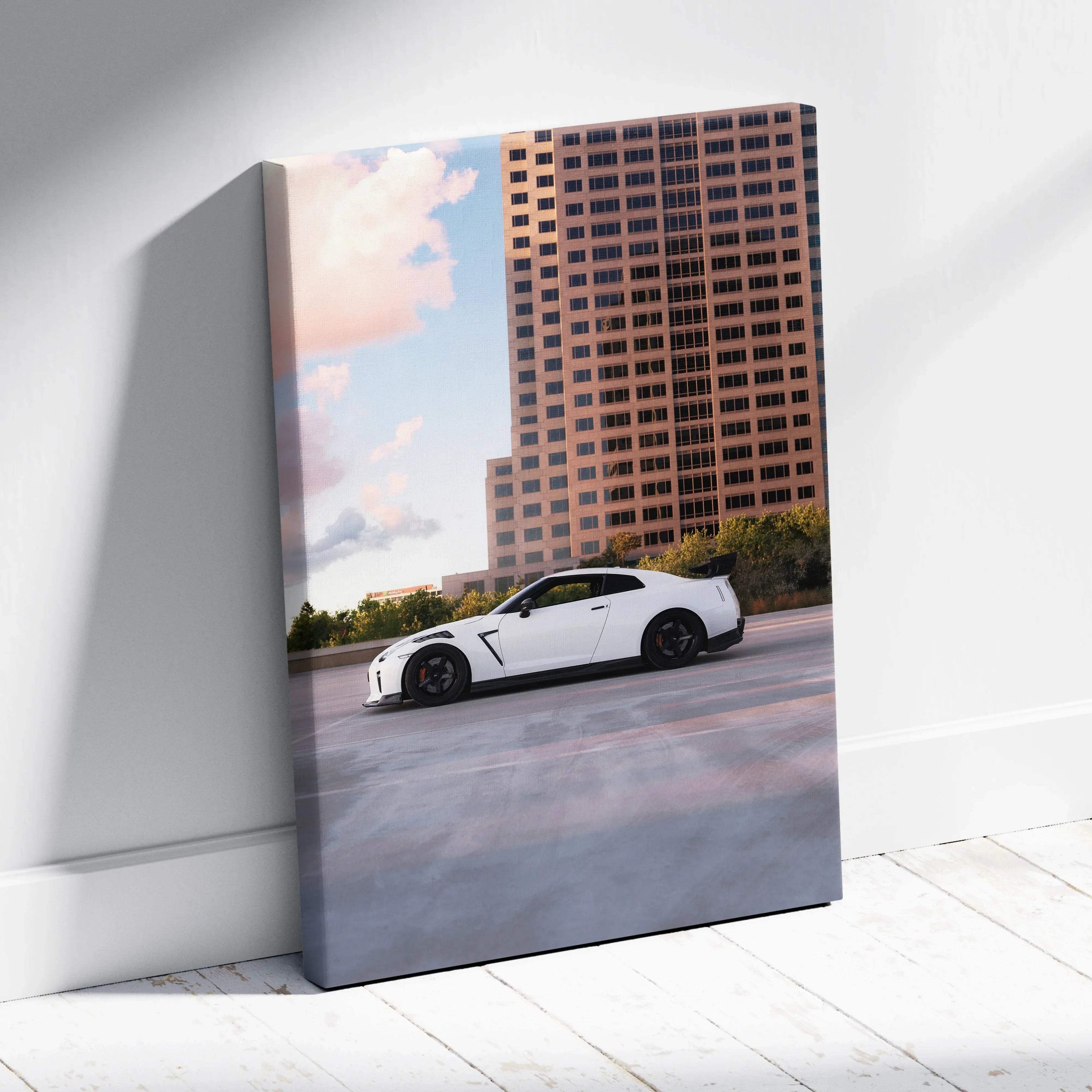 Vertical canvas wall art featuring a white Nissan R35 GTR parked against a sunset cityscape background.