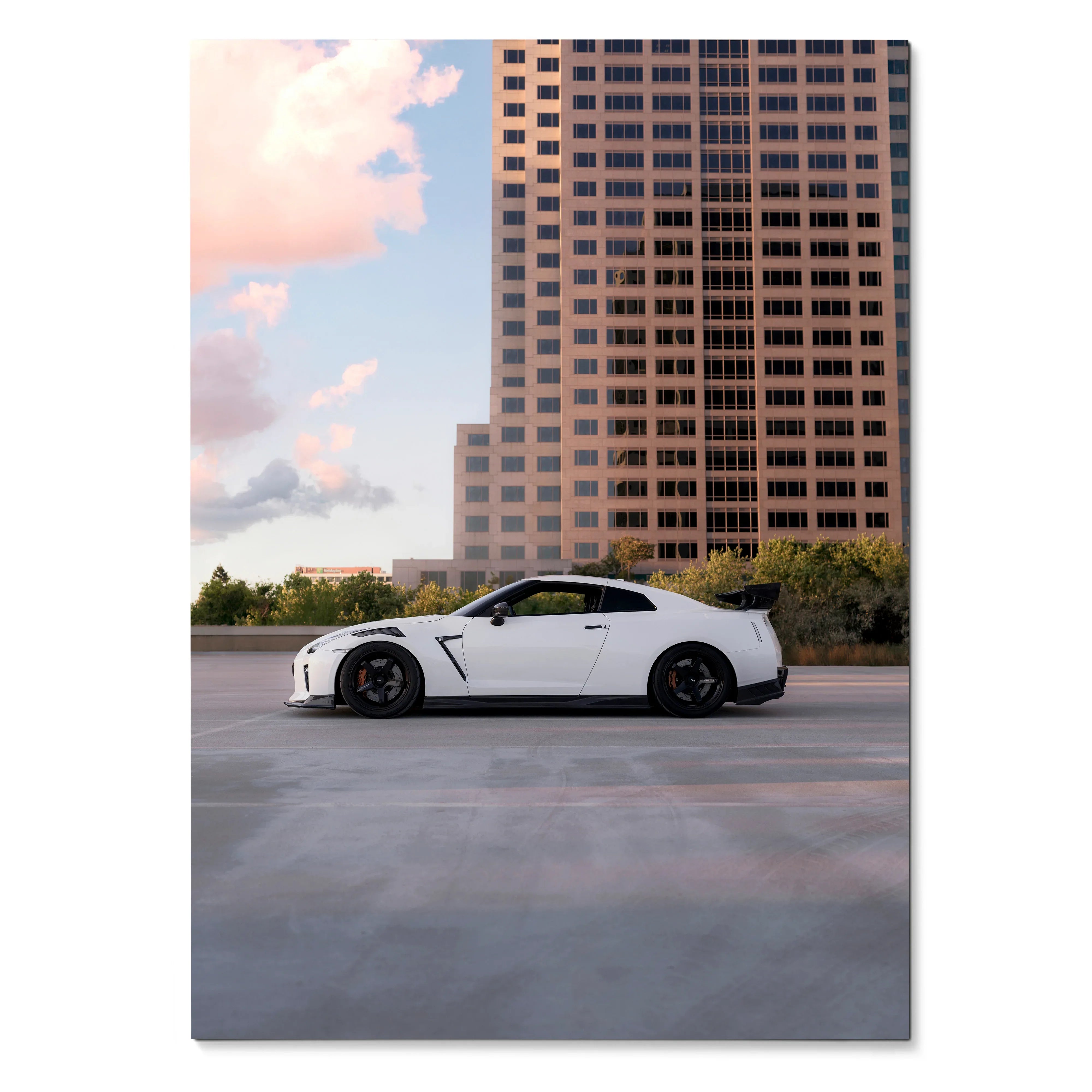 Nissan GTR R35 sports car parked under a sunset sky with city skyscraper background poster wall art.