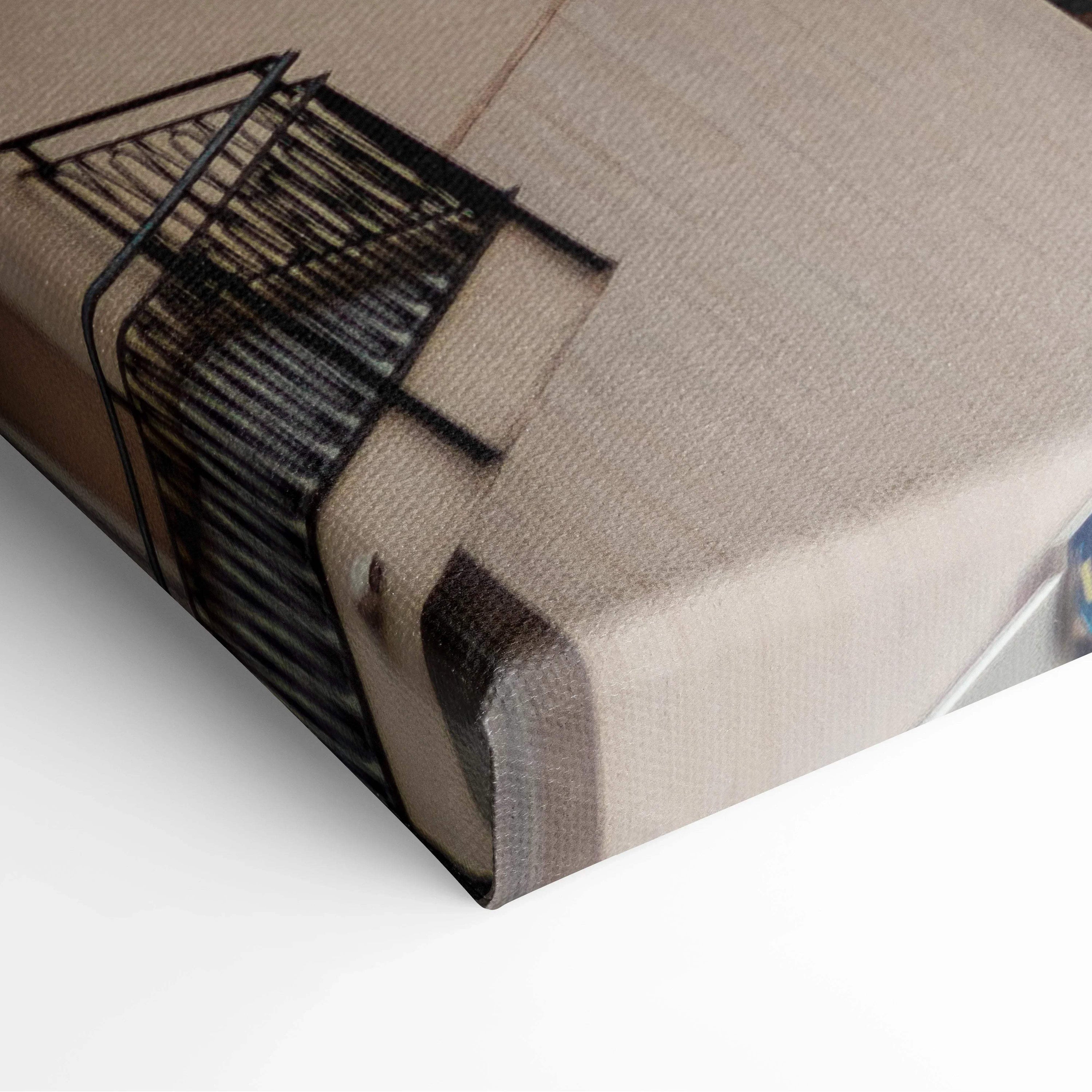 Close-up of canvas art wall print featuring black geometric building design on beige textured fabric.