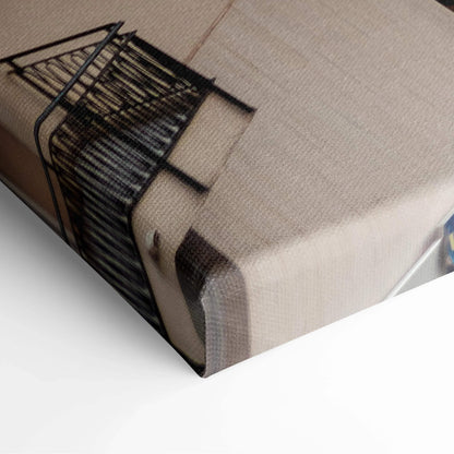 Close-up of canvas art wall print featuring black geometric building design on beige textured fabric.