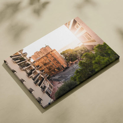 Canvas wall art featuring sunset-lit urban architecture with warm tones and green foliage accents.