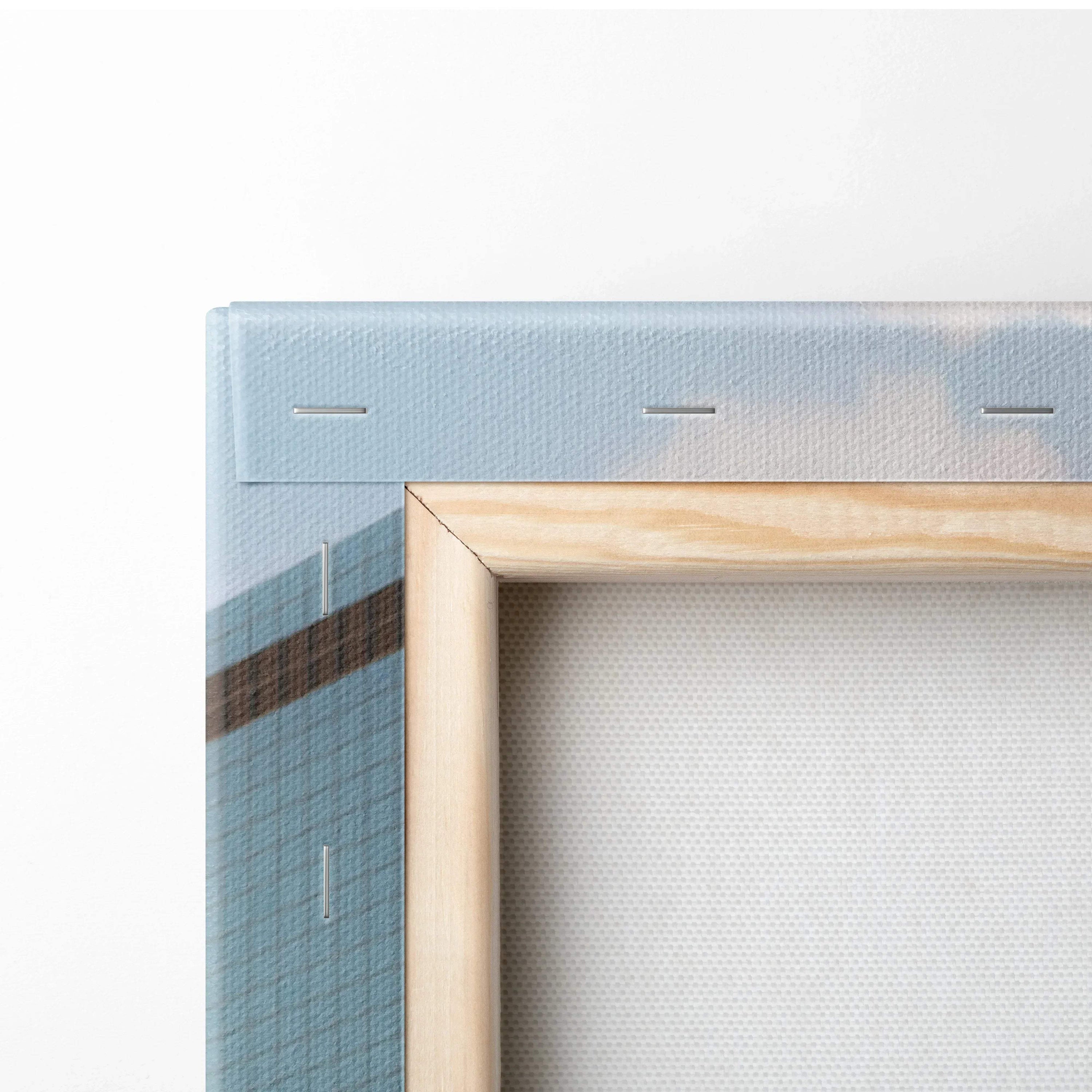 Close-up of canvas wall art corner with wooden frame and blue grid design wrapped around edges.