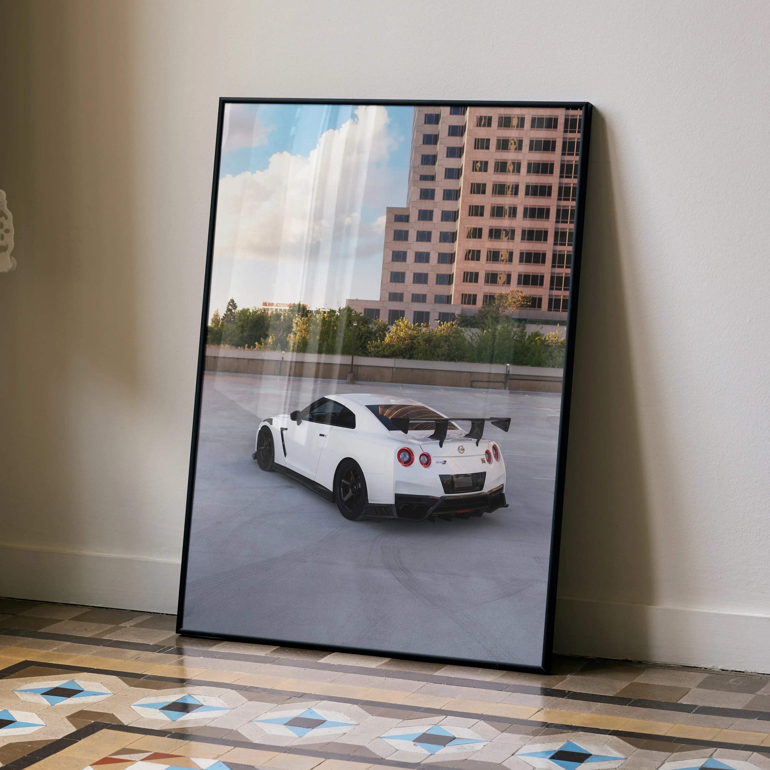 Nissan GTR R35 white sports car driving near modern building poster wall art in black frame.