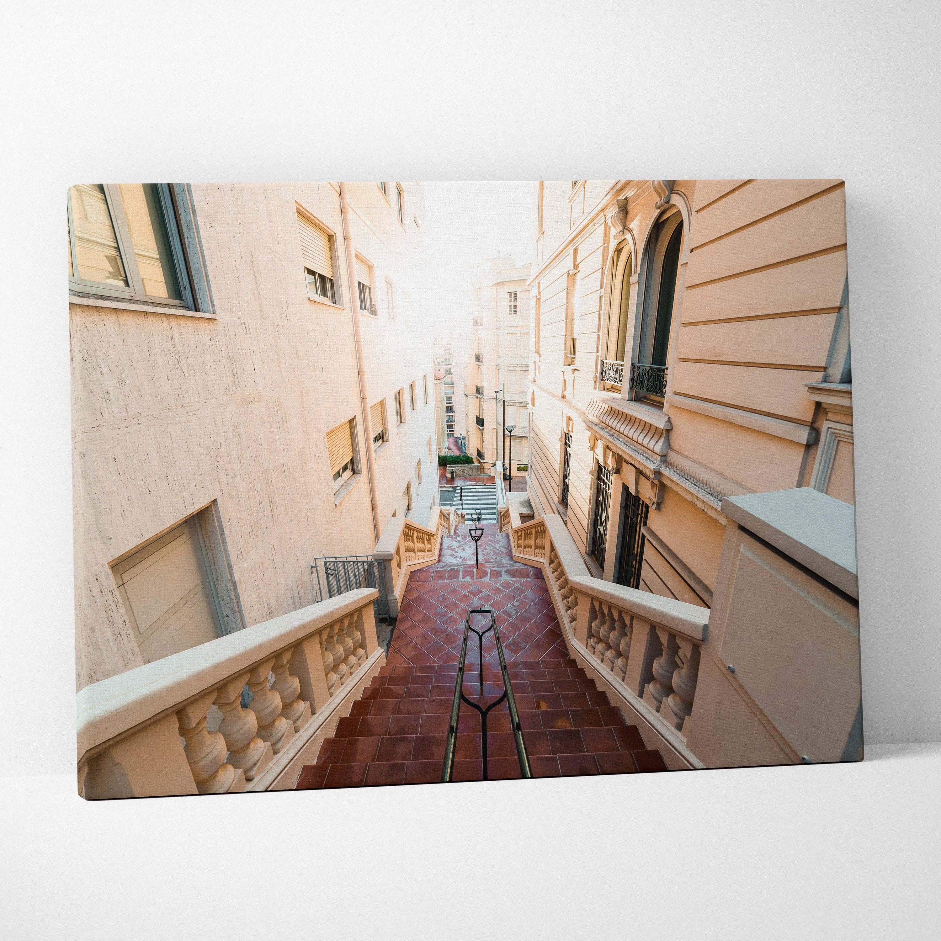 Canvas art depicting a sunlit narrow stairway between beige and white Mediterranean-style buildings, modern wall art piece.
