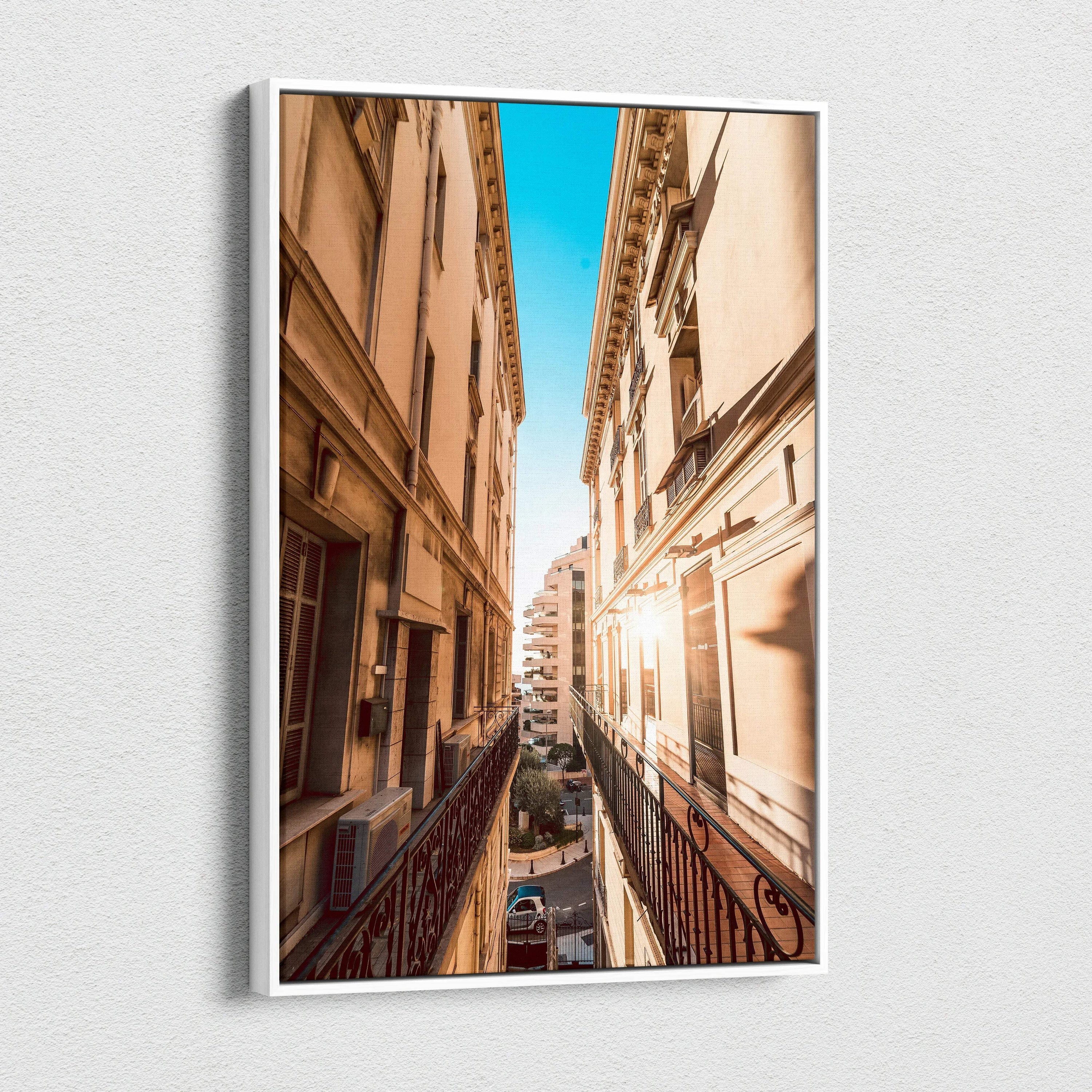 Narrow urban street view between tall beige buildings under bright blue sky on vertical canvas wall art.