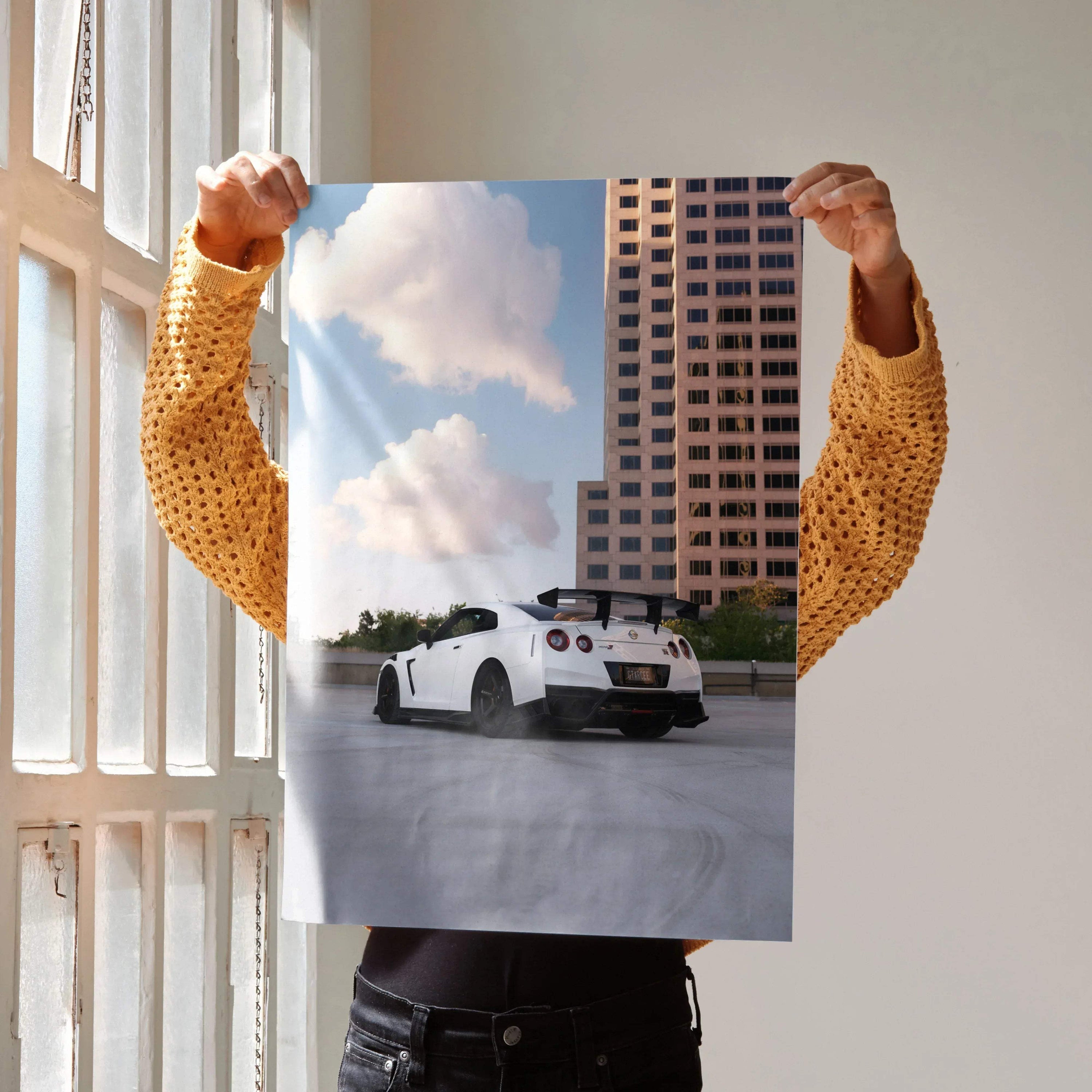 Nissan GTR R35 white sports car driving in urban setting poster wall art.