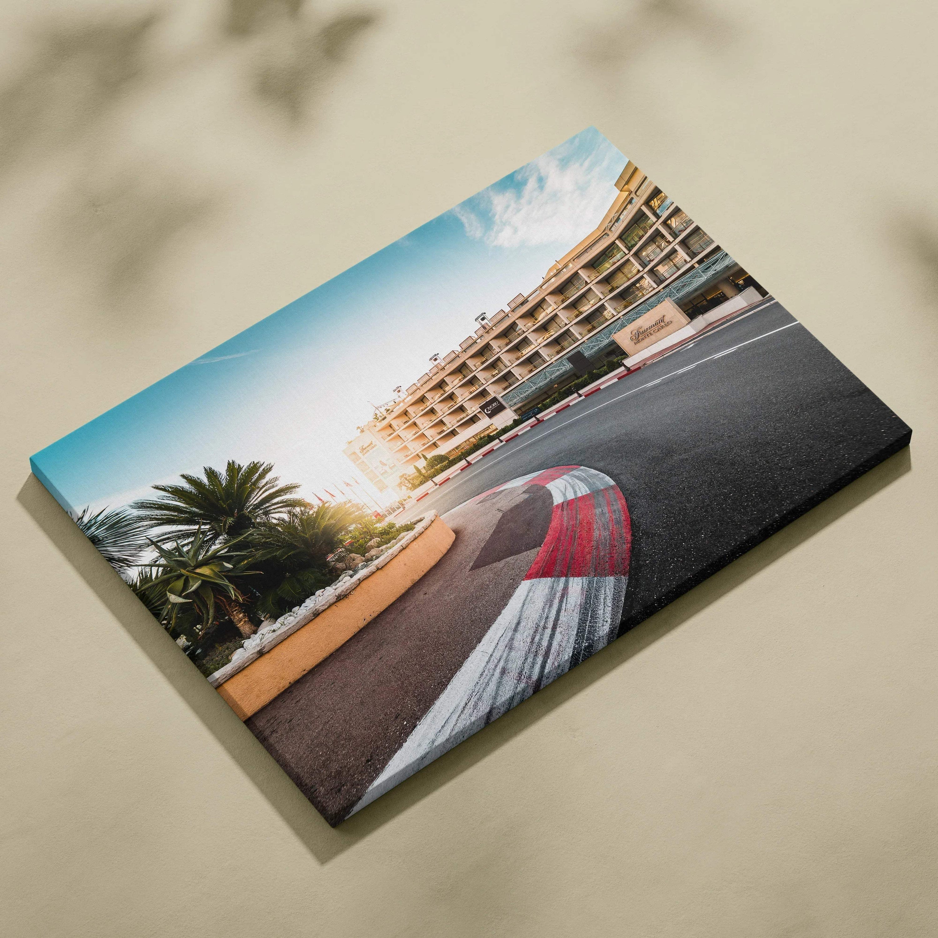 Canvas wall art featuring a vibrant F1 race track corner with red and white curbs, modern buildings, and palm trees under a.