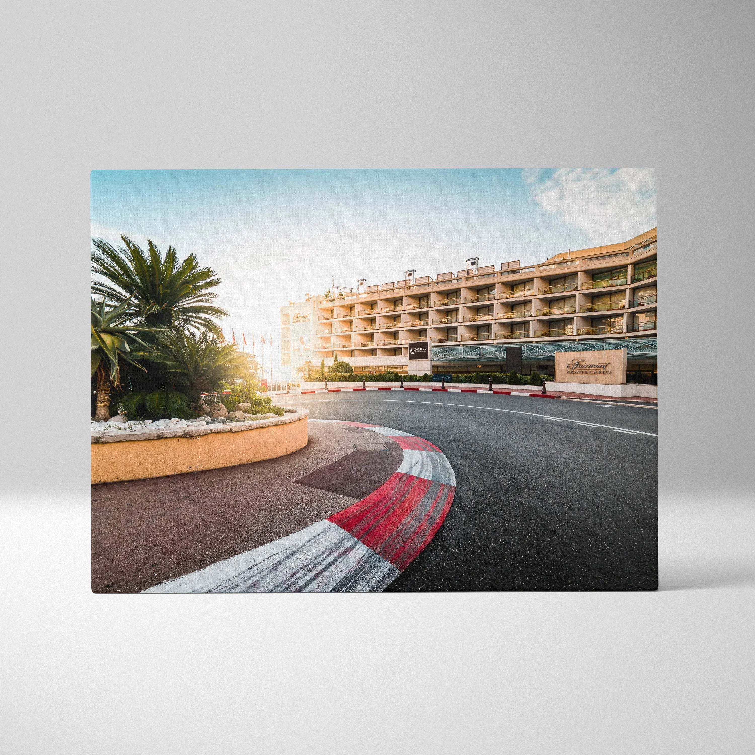 Canvas wall art featuring a curved racetrack with red and white curbs, palm trees, and modern buildings under a bright sky.