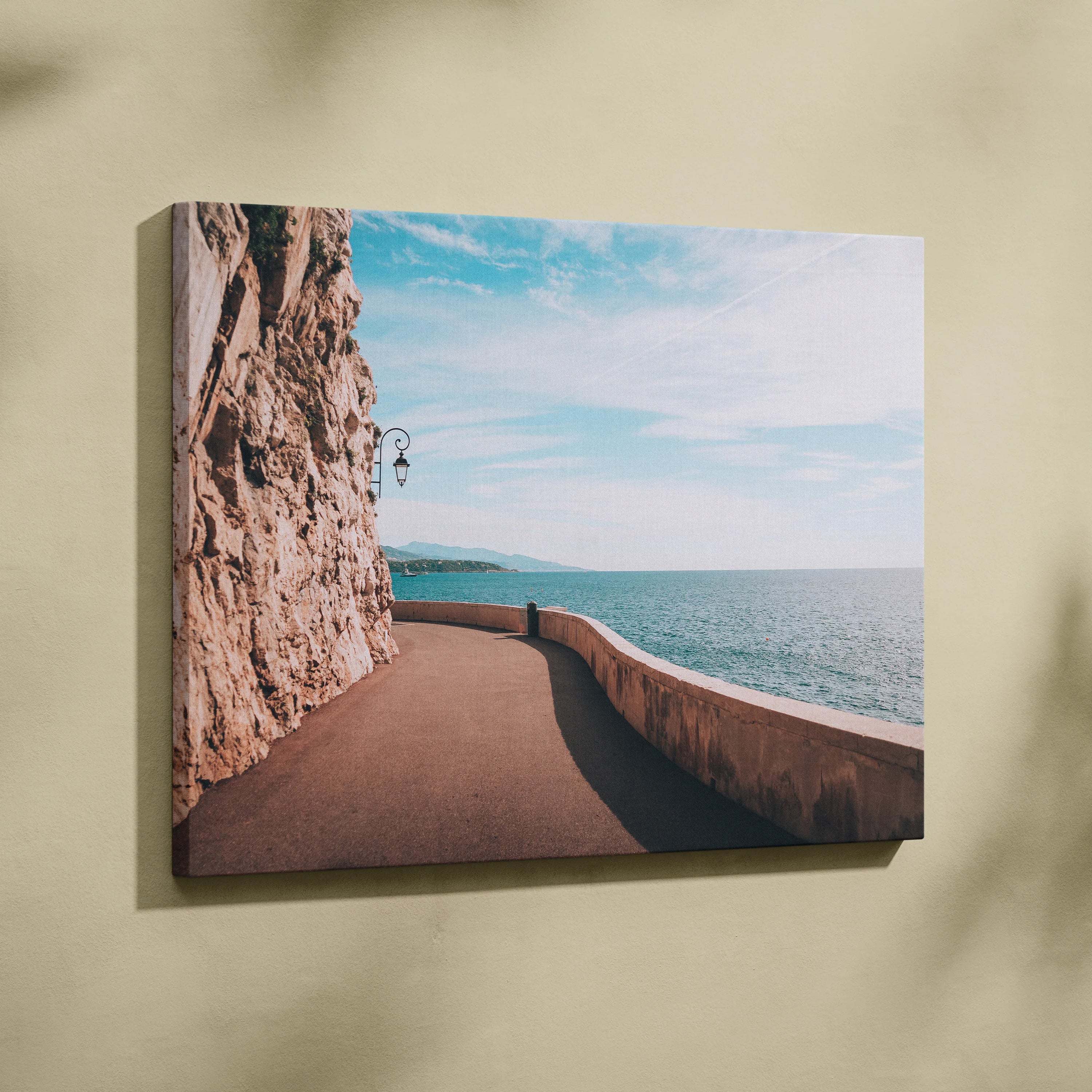 Canvas wall art featuring a curved ocean walkway beside rocky cliffs under a blue sky.