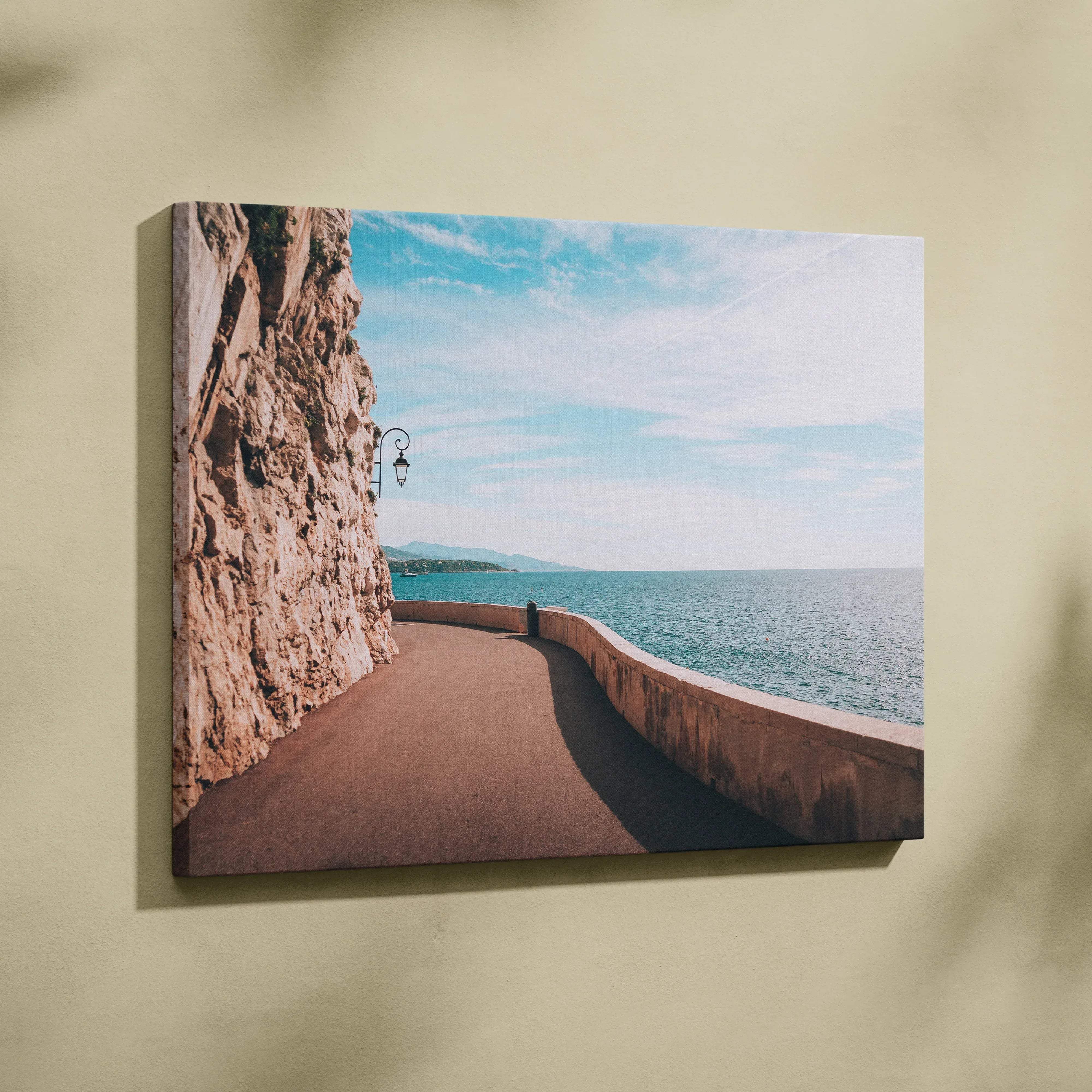 Rectangular canvas print of a coastal pathway with rugged cliffs and turquoise ocean in ocean blues and warm stone tones