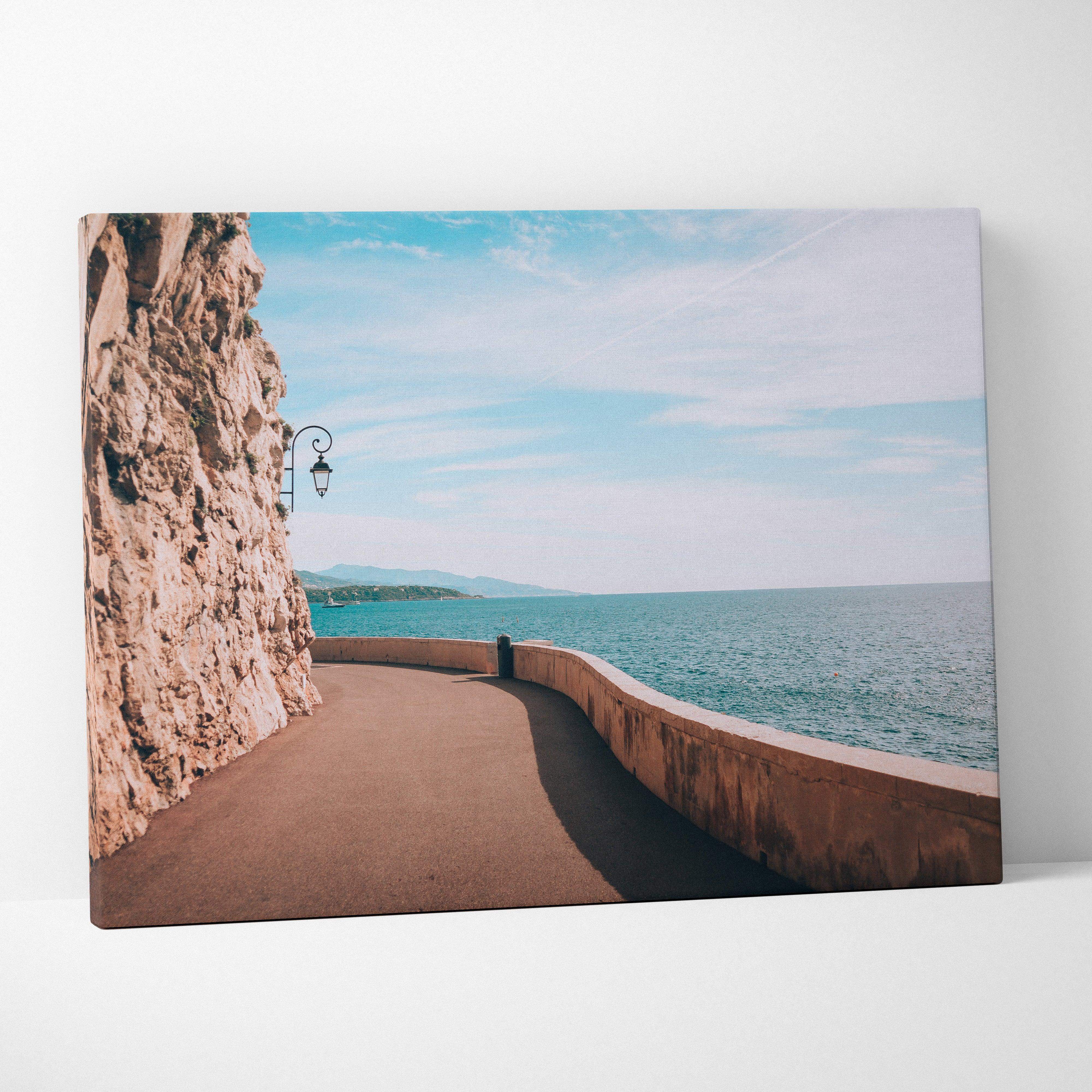 A rectangular canvas print of a coastal pathway with cliffs and turquoise ocean in ocean blues and warm stone tones
