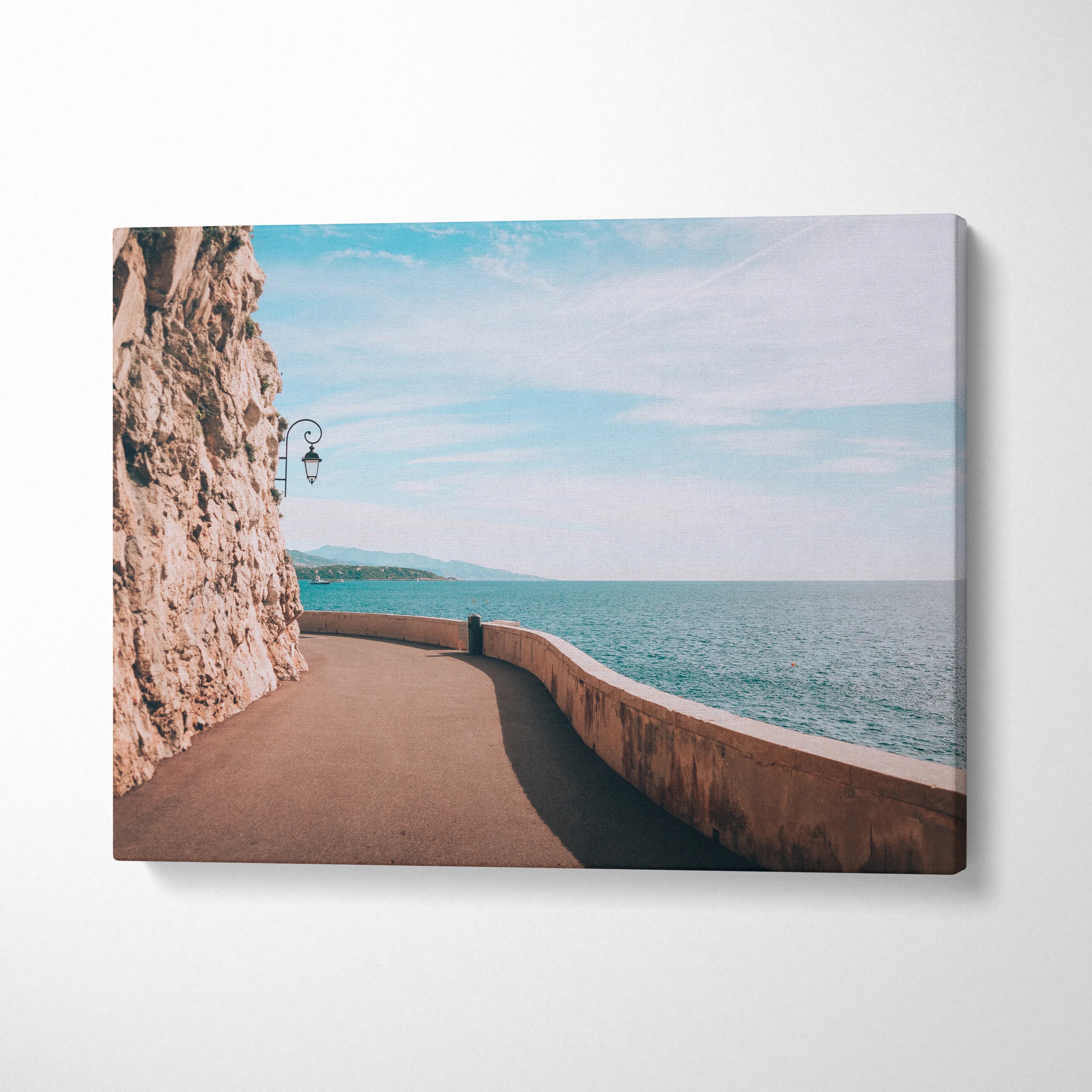 Ocean view pathway along rocky cliff with blue sky, canvas wall art print.