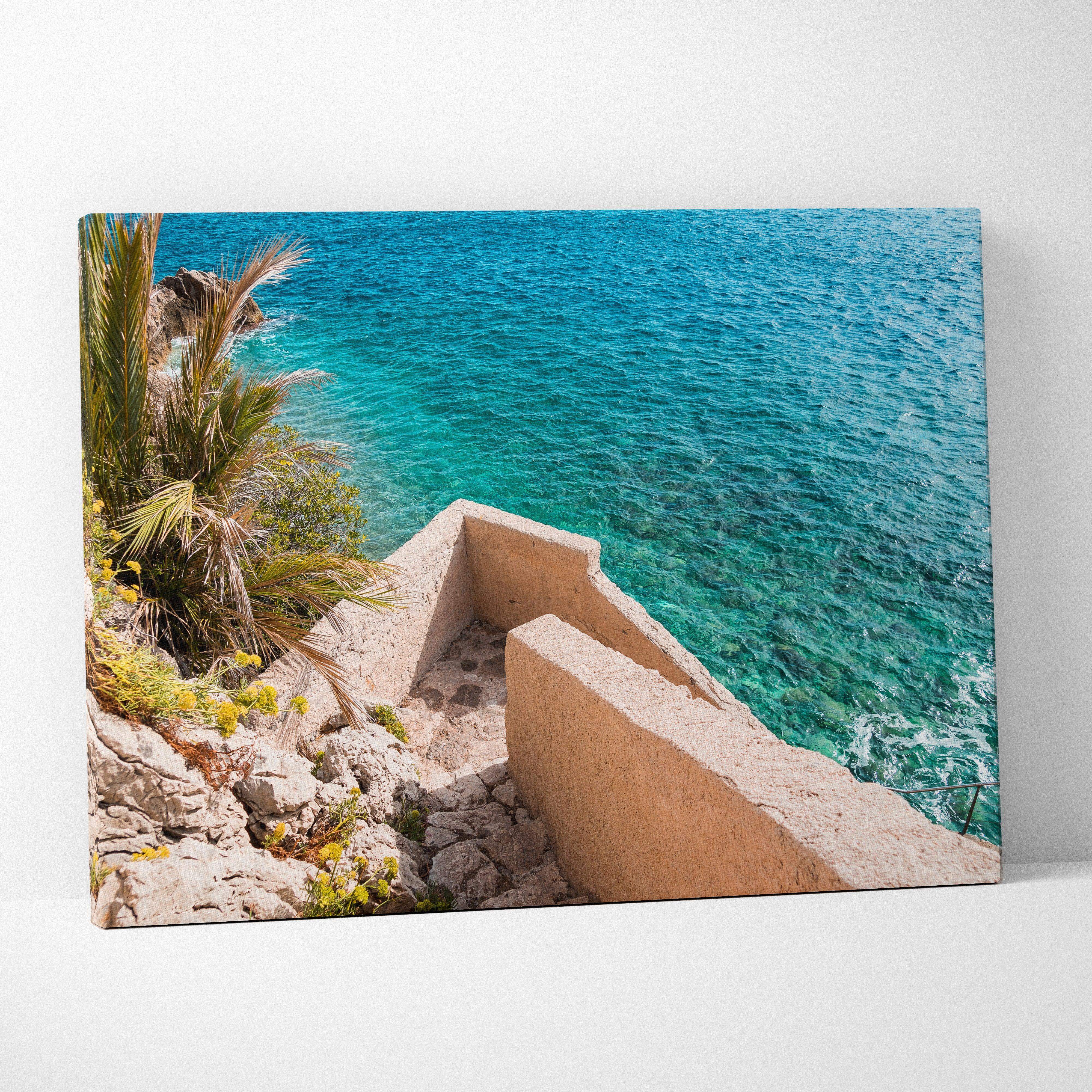 Canvas wall art featuring a vibrant turquoise ocean view with stone steps and palm trees for coastal decor
