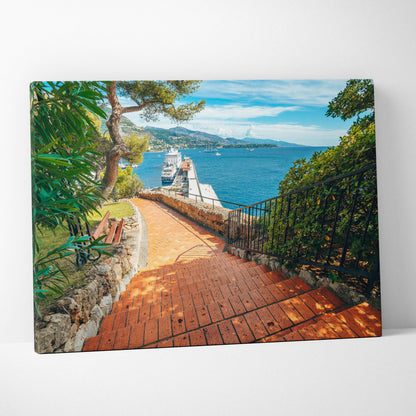 Canvas wall art featuring a sunlit brick pathway leading to a dock with boats, bordered by green trees and blue ocean.
