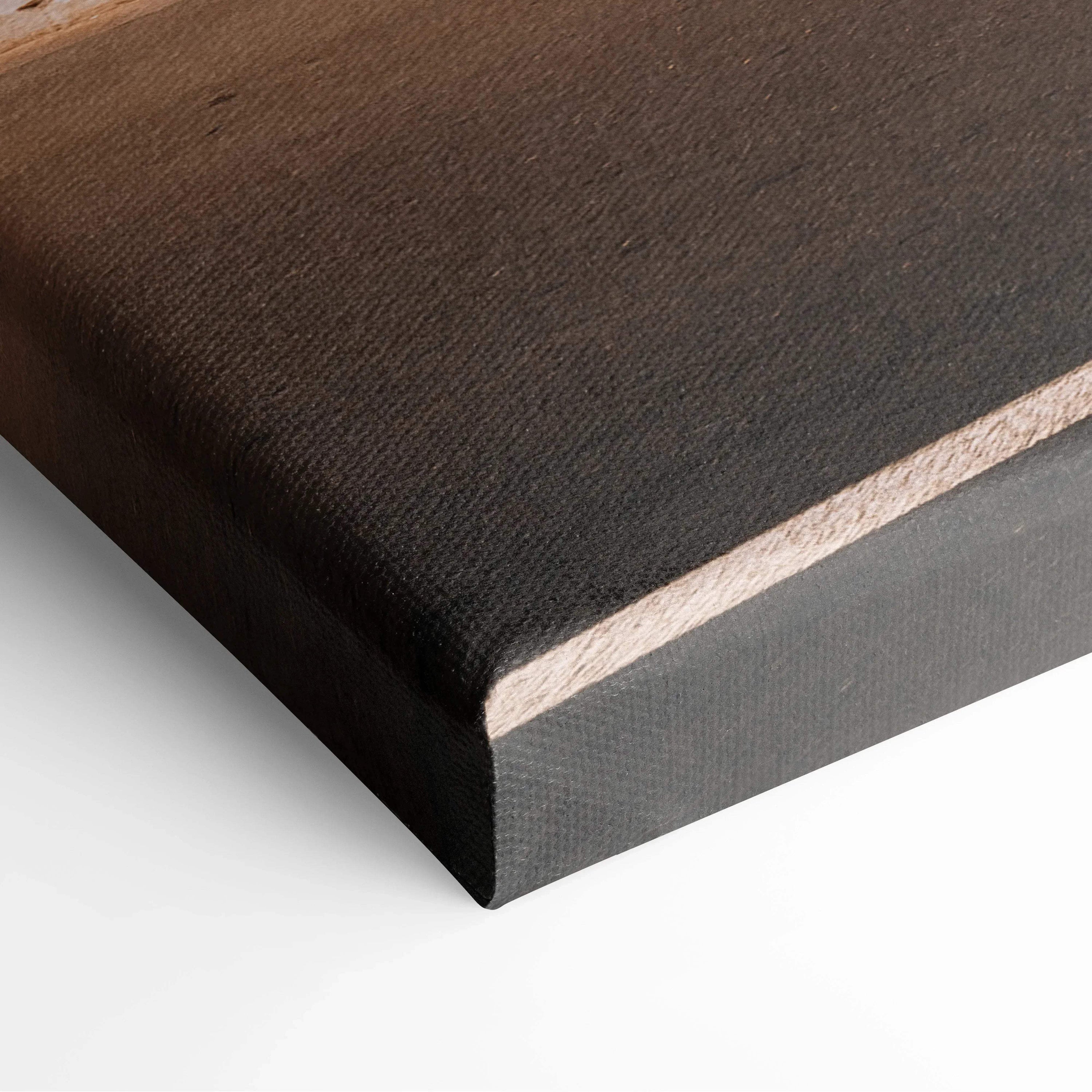 Close-up of black textured canvas stretched over wooden frame, showcasing fine weave and wrapped edges for wall art display.
