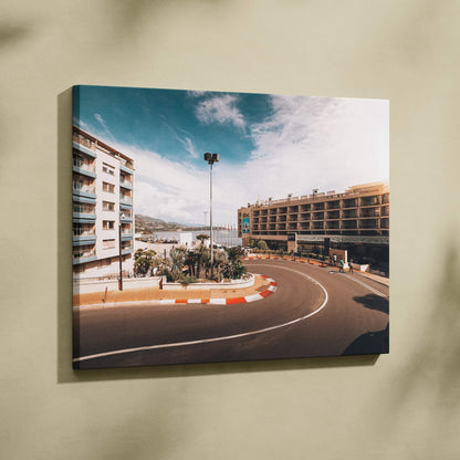 Canvas wall art featuring a sharp F1 track corner with surrounding modern buildings under a partly cloudy sky.
