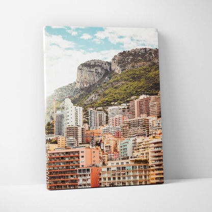 Canvas wall art depicting colorful urban buildings with mountainous backdrop under a blue sky.