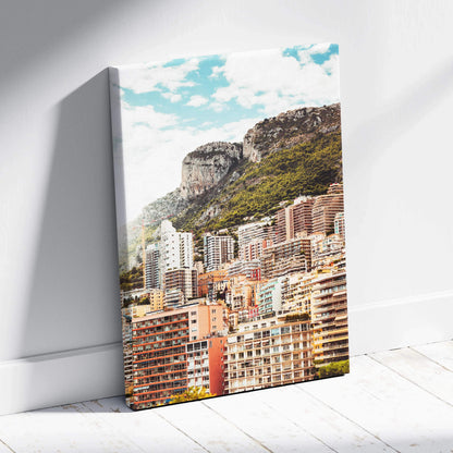Canvas wall art featuring a colorful cityscape with high-rise buildings and a rocky mountain under a bright blue sky.