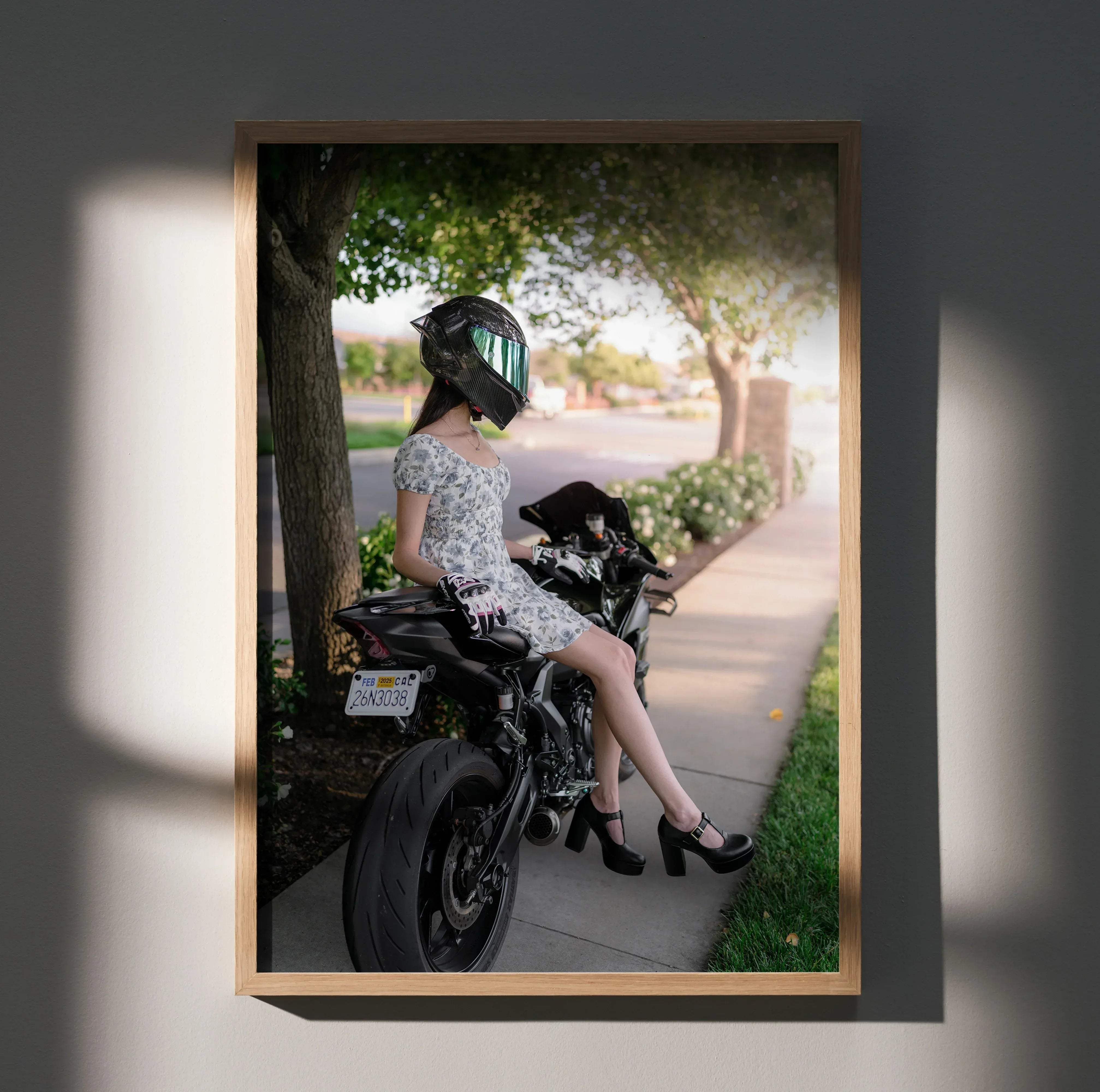 A framed biker poster featuring a woman in a floral dress on a black yamaha r7 wearing an agv pista helmet with green visor