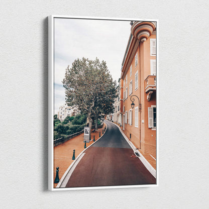 Canvas wall art featuring a curved street lined with a tall tree and historic orange-toned buildings under a cloudy sky.