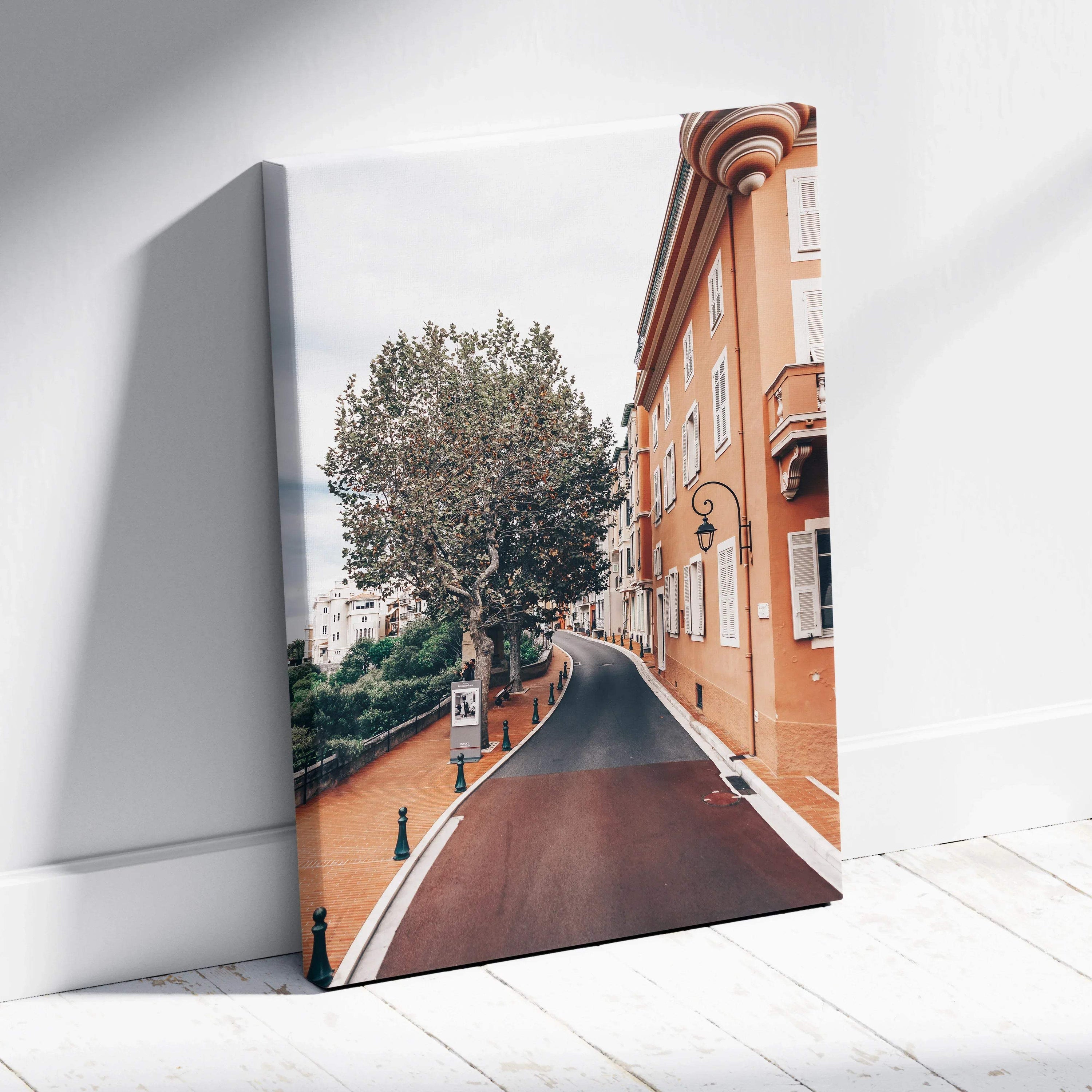 Canvas wall art featuring a sunlit street with a large tree and classic orange buildings under a bright sky.