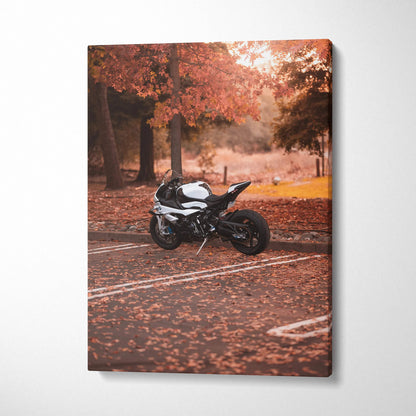 Vertical canvas art of a black BMW S1000RR motorcycle parked on autumn leaves in a forest setting wall art.