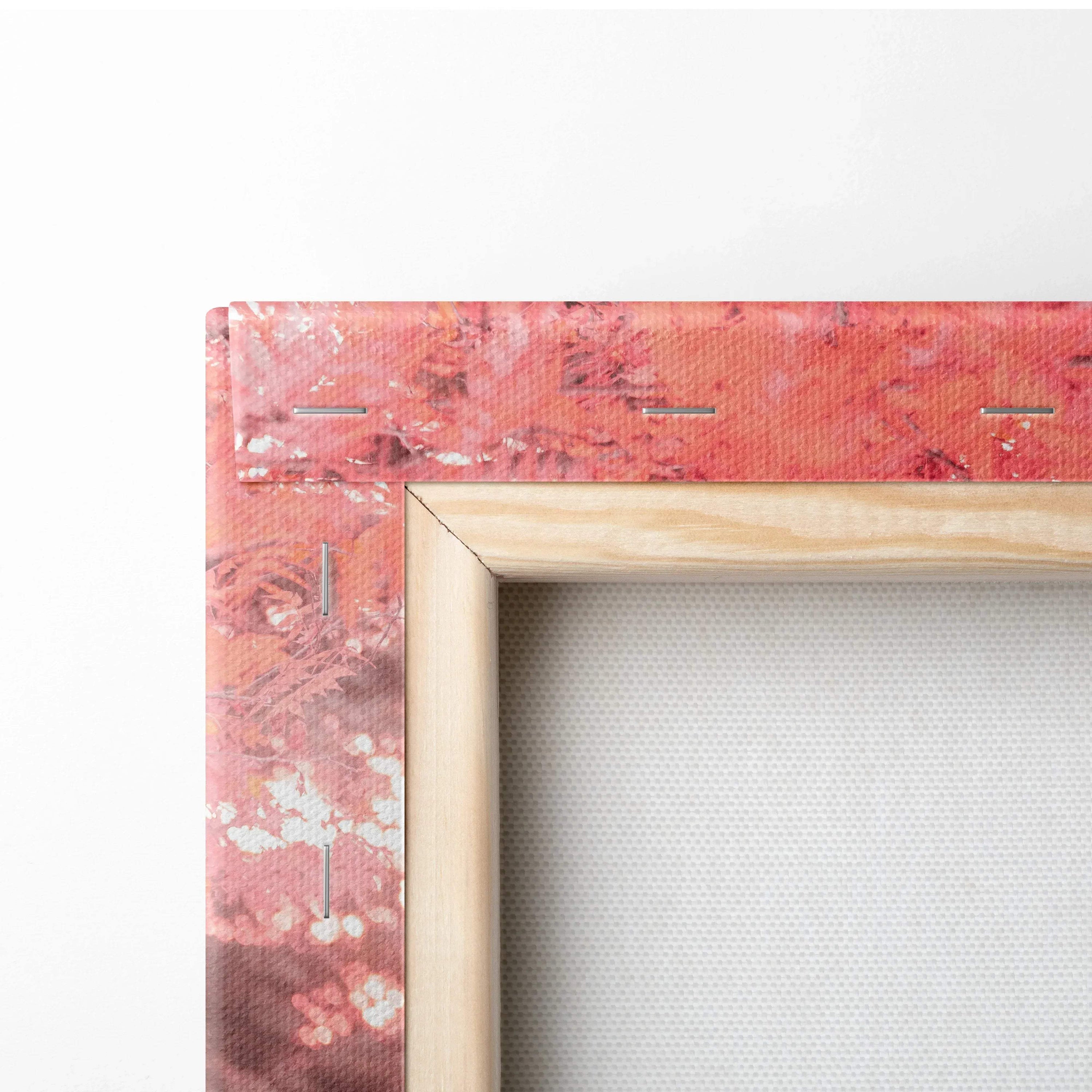 Close-up of wooden frame corner on textured vertical canvas art with red and pink abstract design.