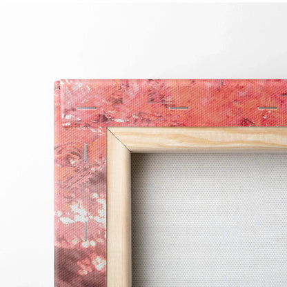 Close-up of wooden frame corner on textured vertical canvas art with red and pink abstract design.