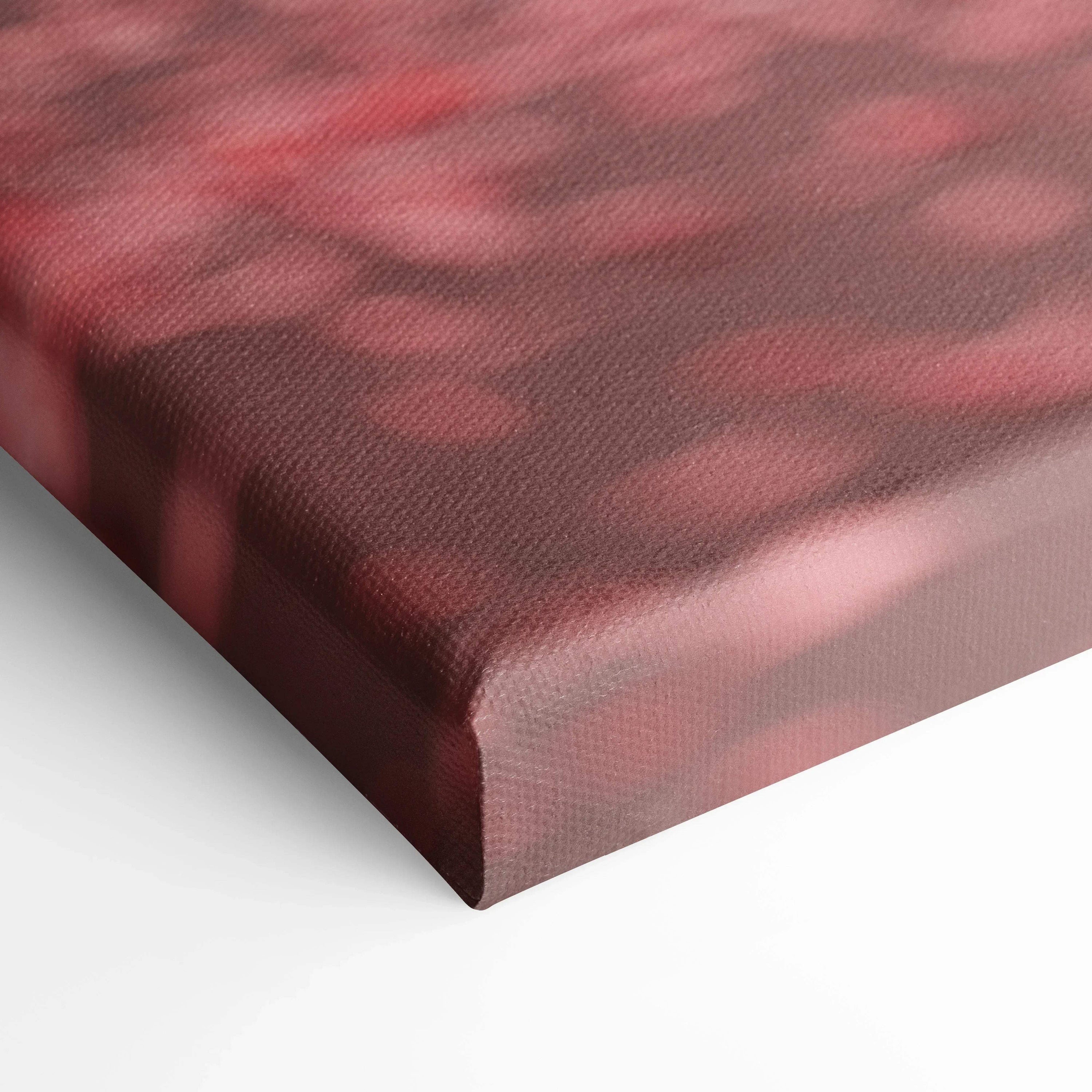 Close-up of red and black abstract design on textured museum-quality canvas wall art with wrapped edges.