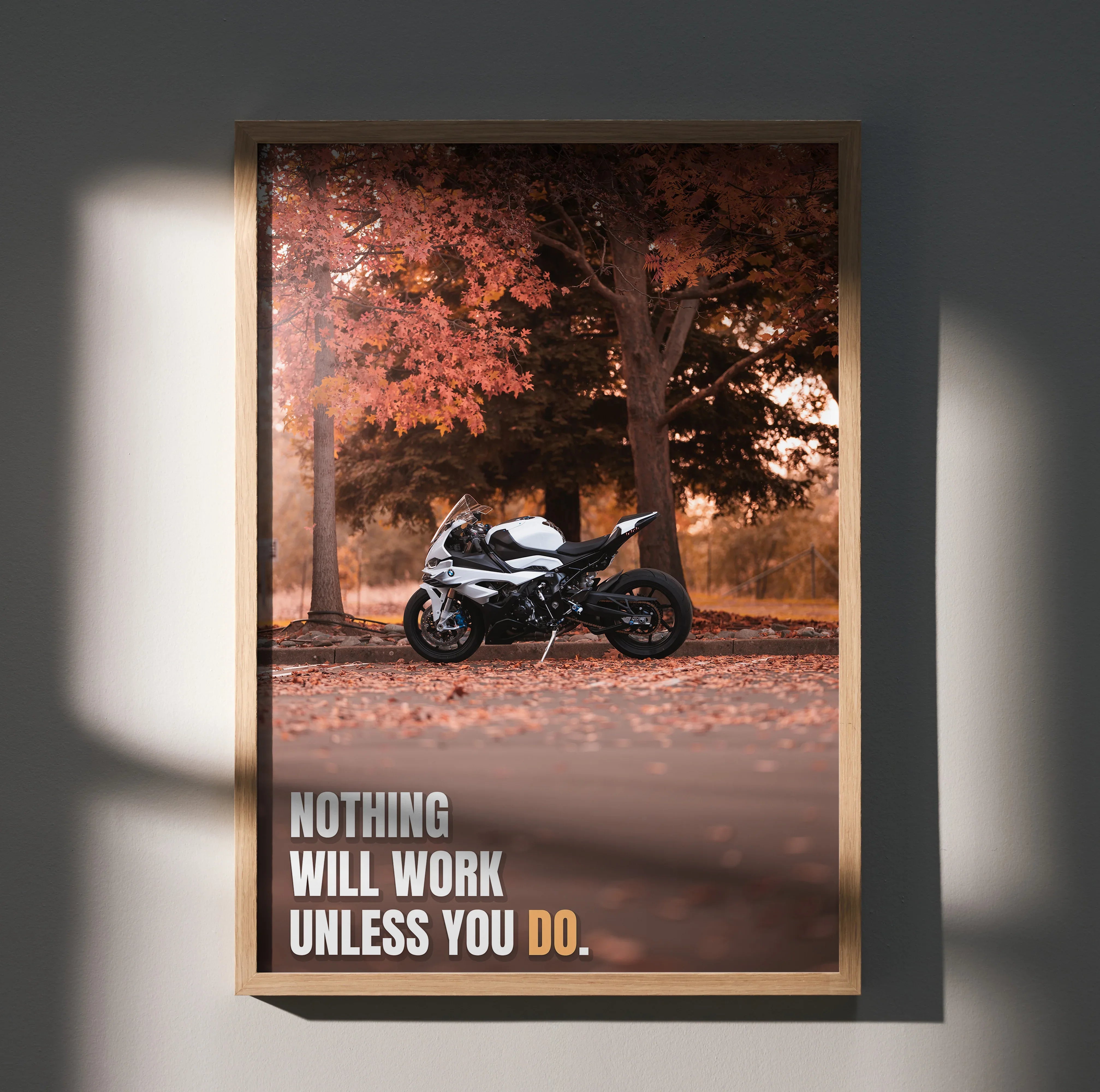 Motivational poster featuring BMW S1000RR motorcycle with fall trees and inspiring text on wall art.