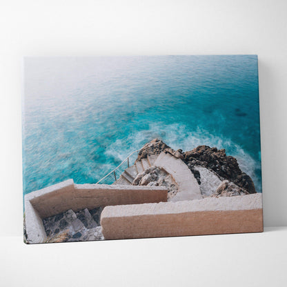 Canvas wall art featuring a curved stone staircase descending to turquoise ocean waters with rocky shore details.
