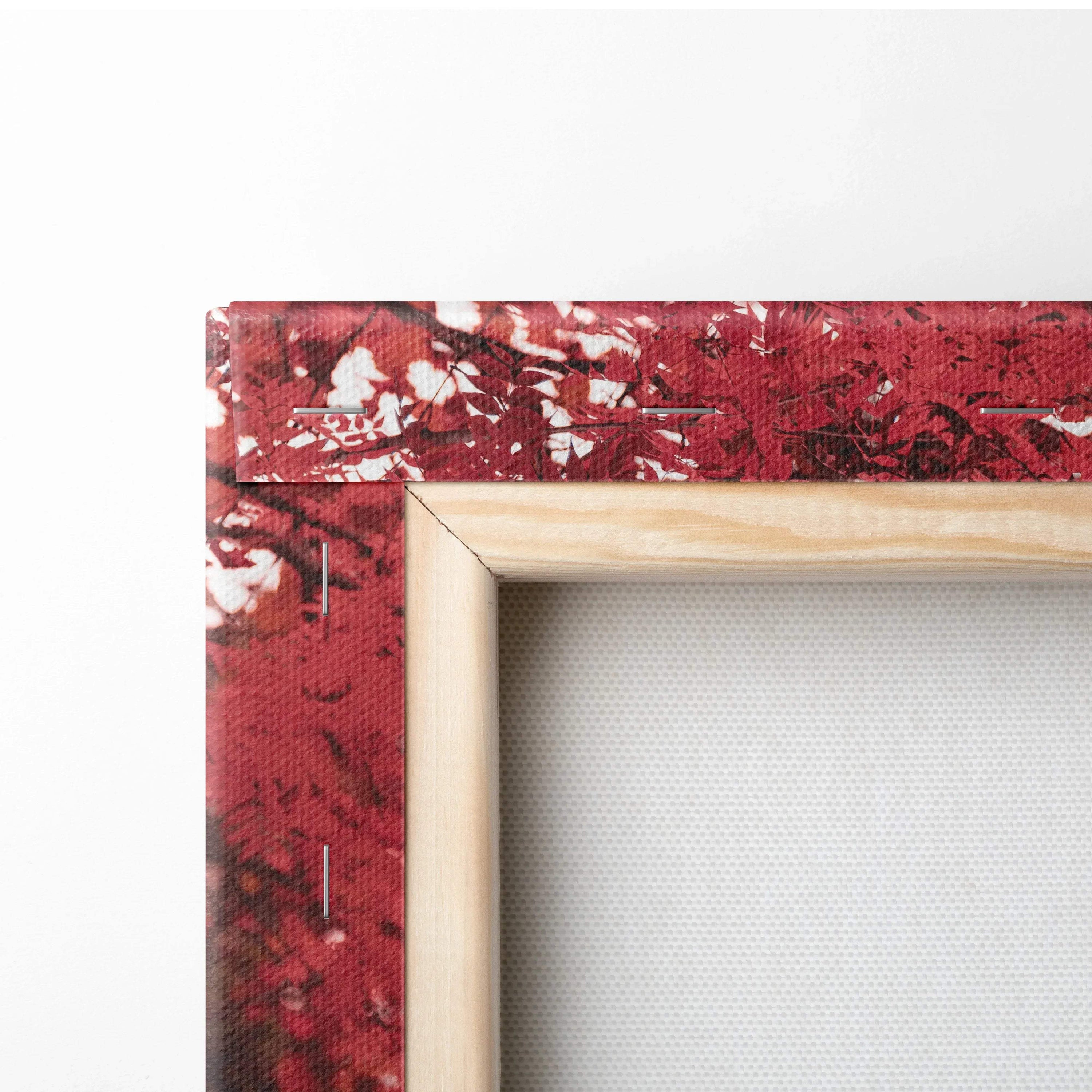 Close-up of wooden frame corner with red abstract art on canvas wall art.
