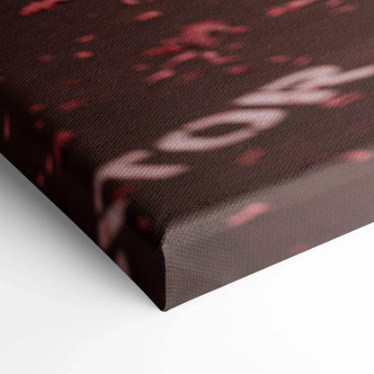 Close-up of textured black and red canvas wall art with abstract design and subtle text details.