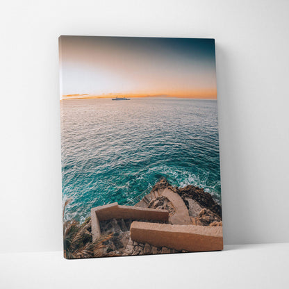 Canvas wall art featuring a coastal view with a stairway descending to turquoise ocean water under a soft orange and blue.